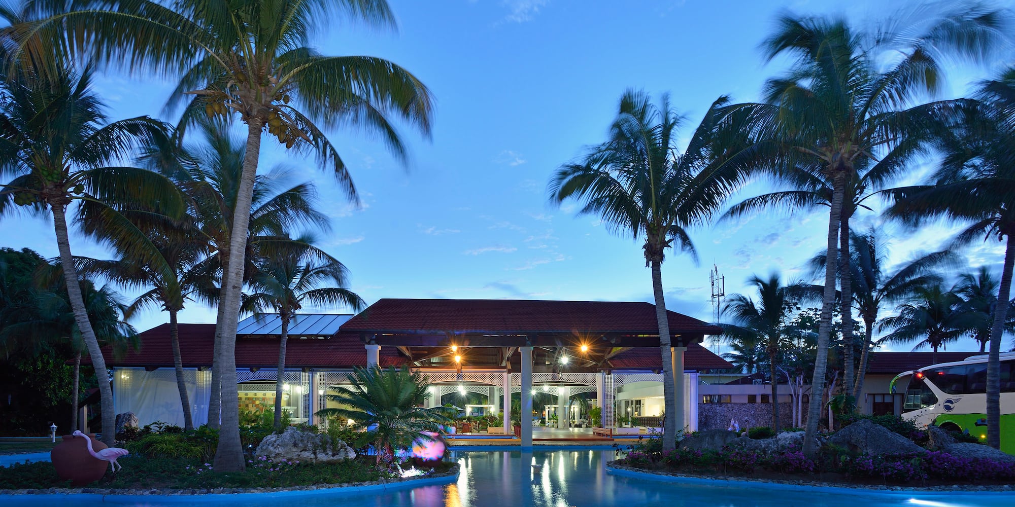 a pool with palm trees and a building