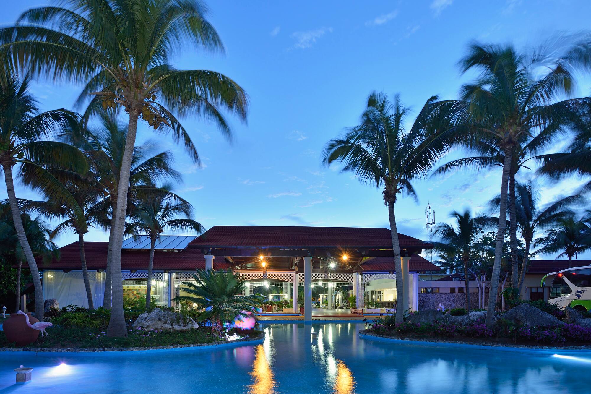 a pool with palm trees and a building
