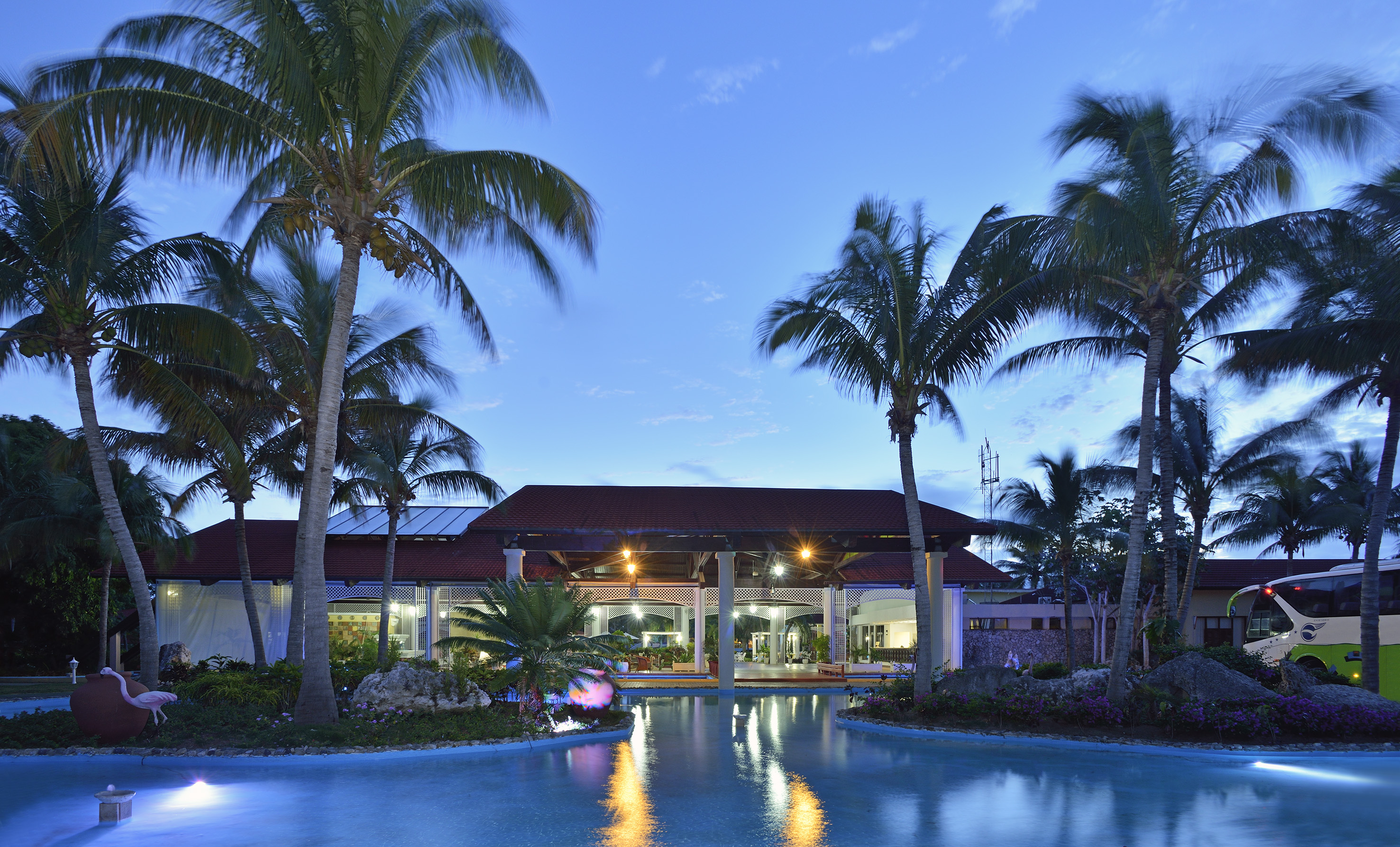 a pool with palm trees and a building