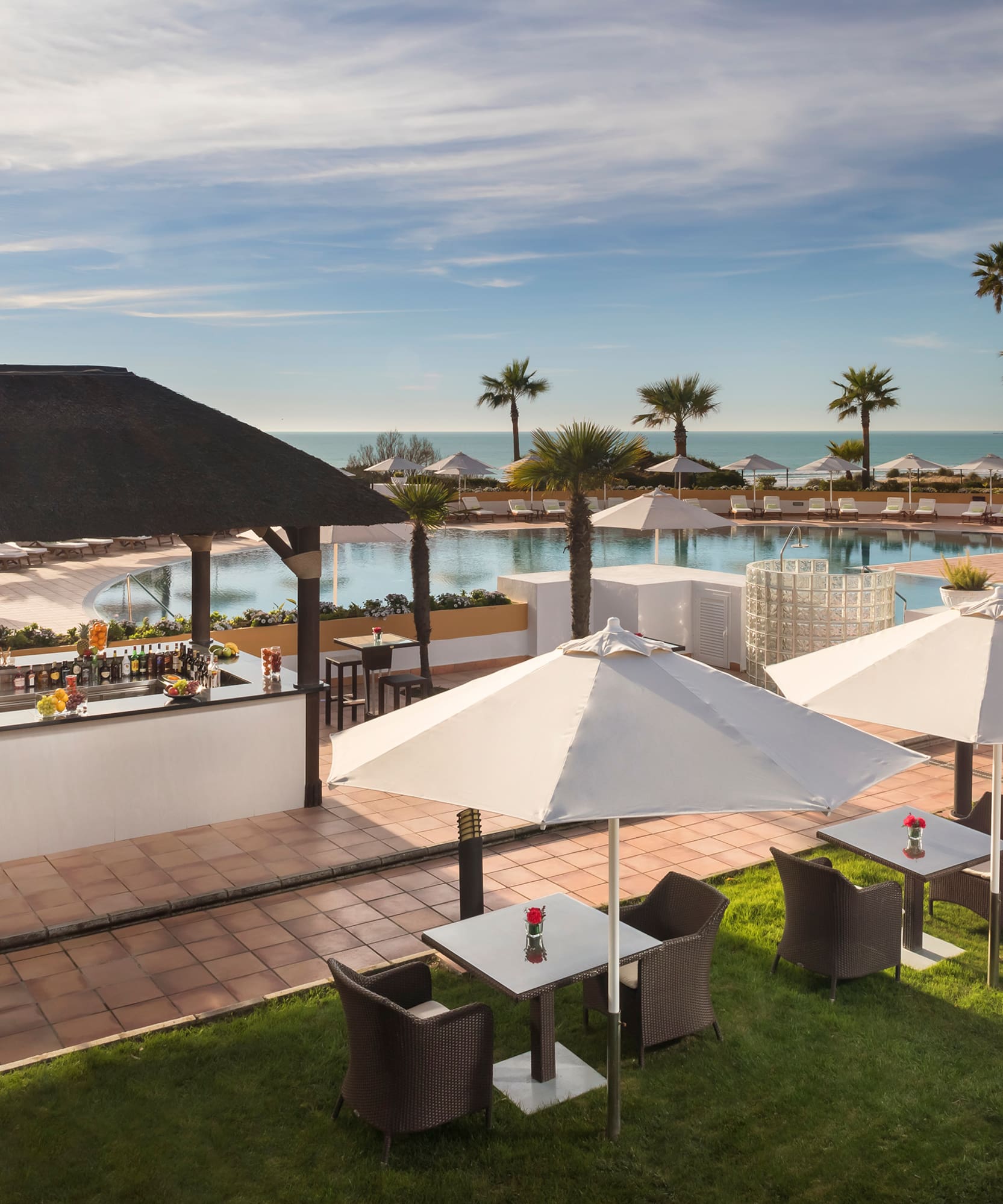 a pool with tables and chairs and umbrellas