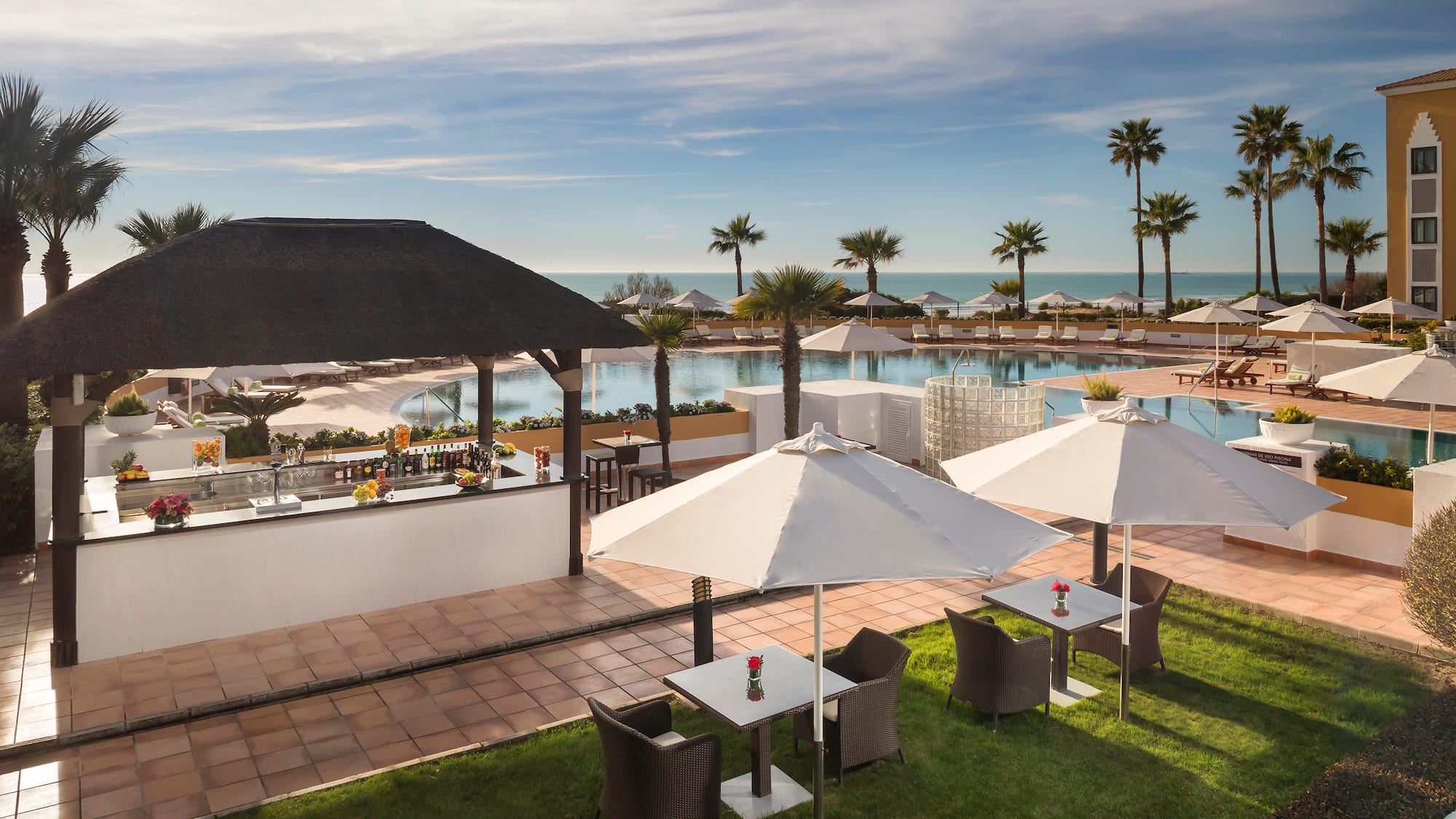 a pool with tables and chairs and umbrellas