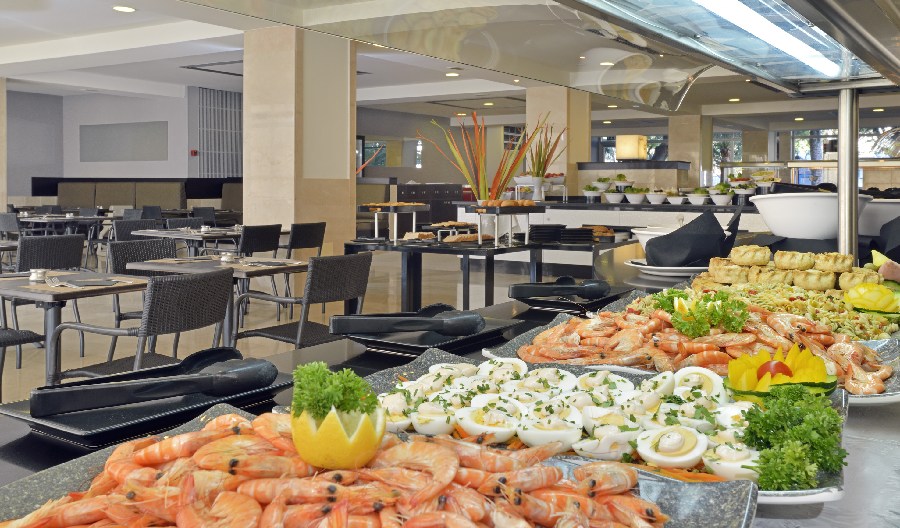 Modern resort restaurant buffet with fresh shrimp, deviled eggs, pasta salad.