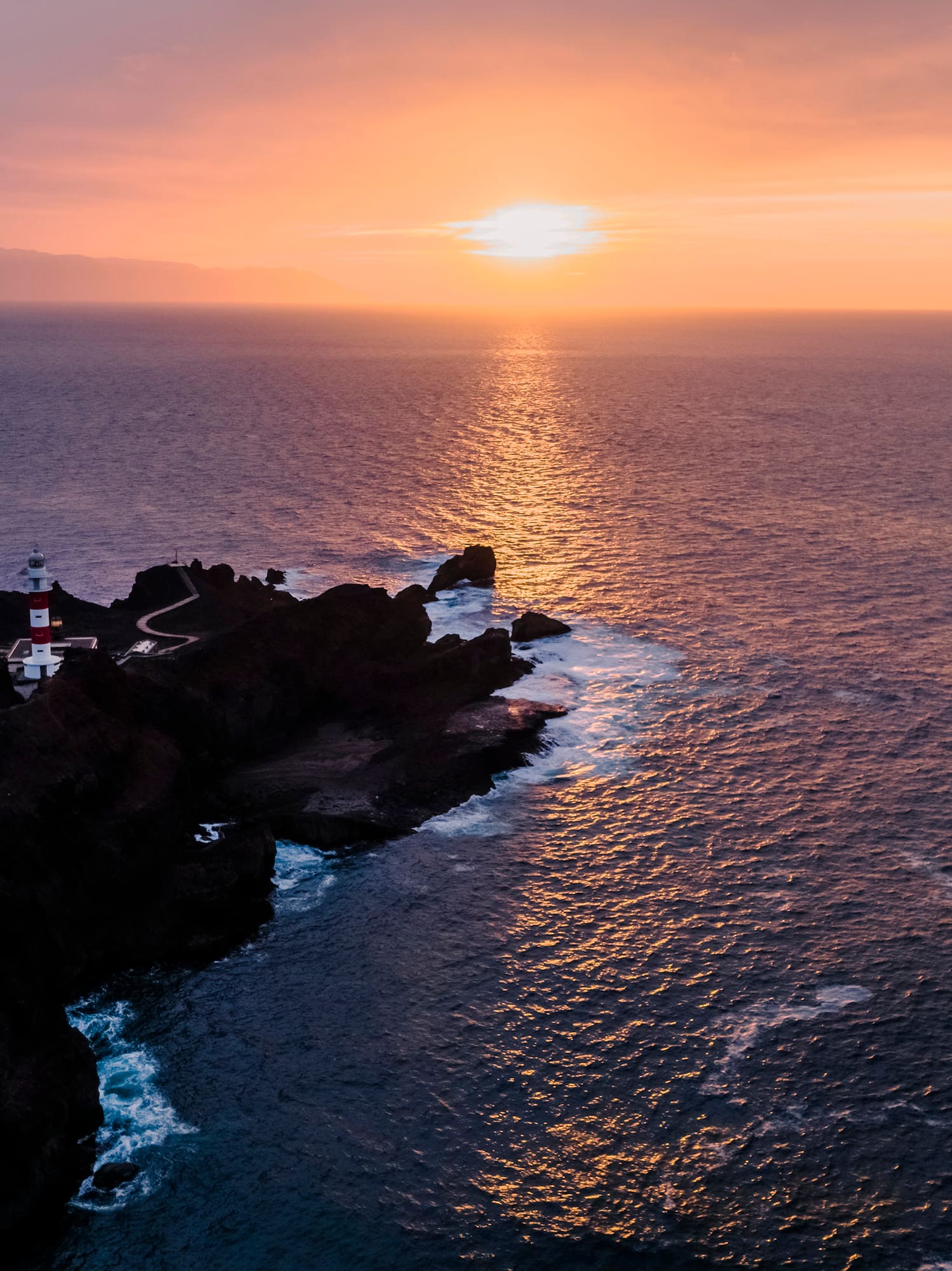 a lighthouse on a rocky island in the ocean