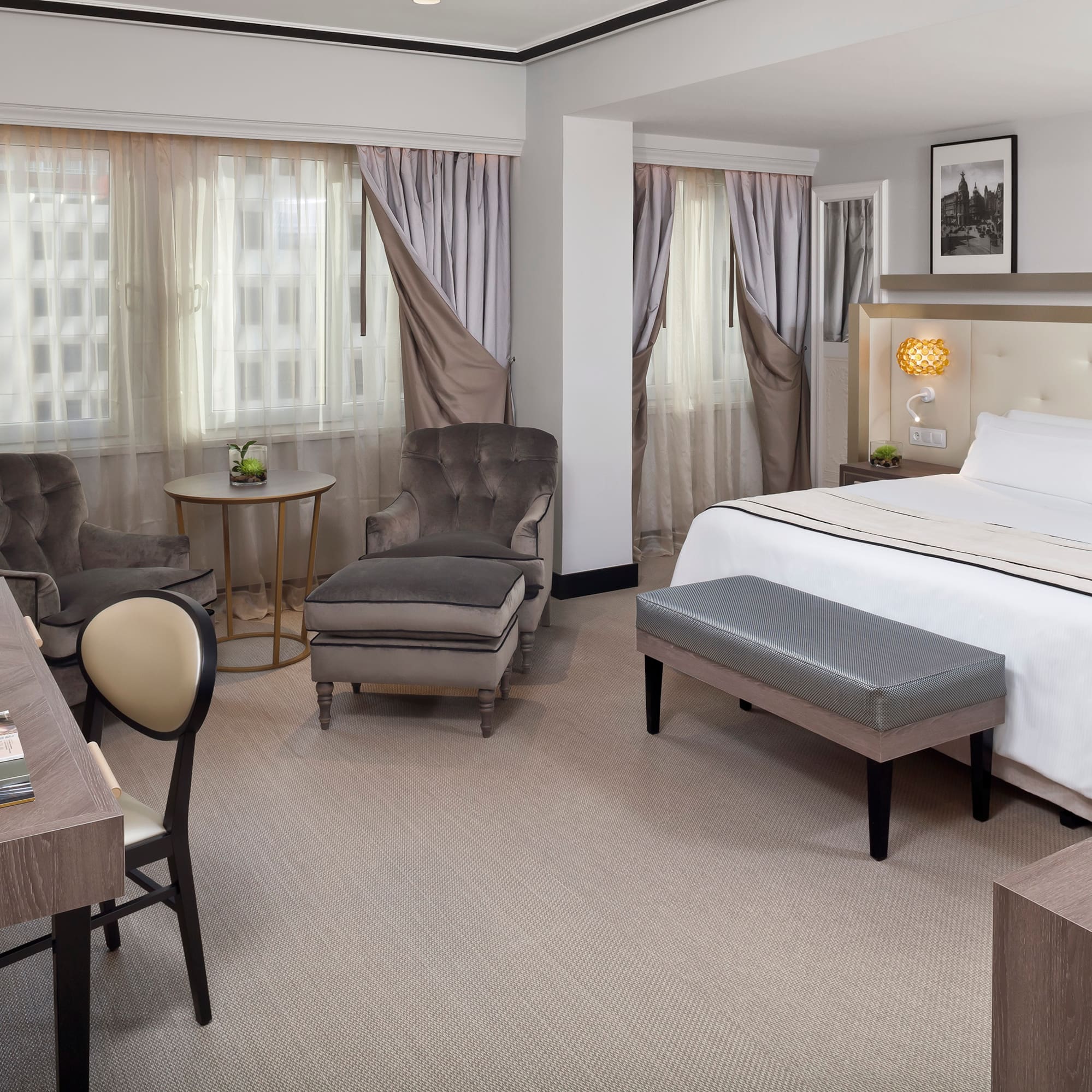 a room with a bed and chairs