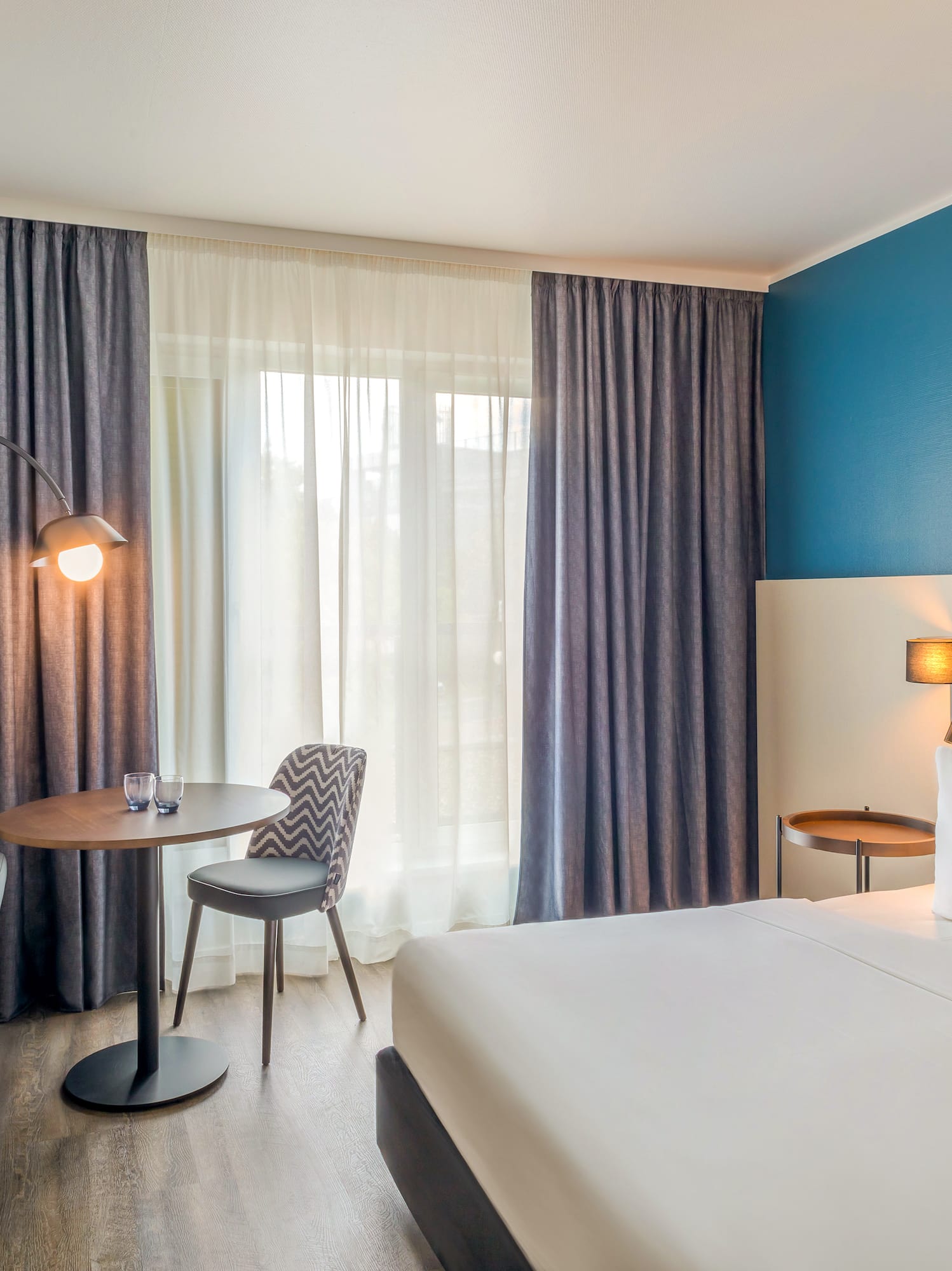 a room with a bed and a table and chairs