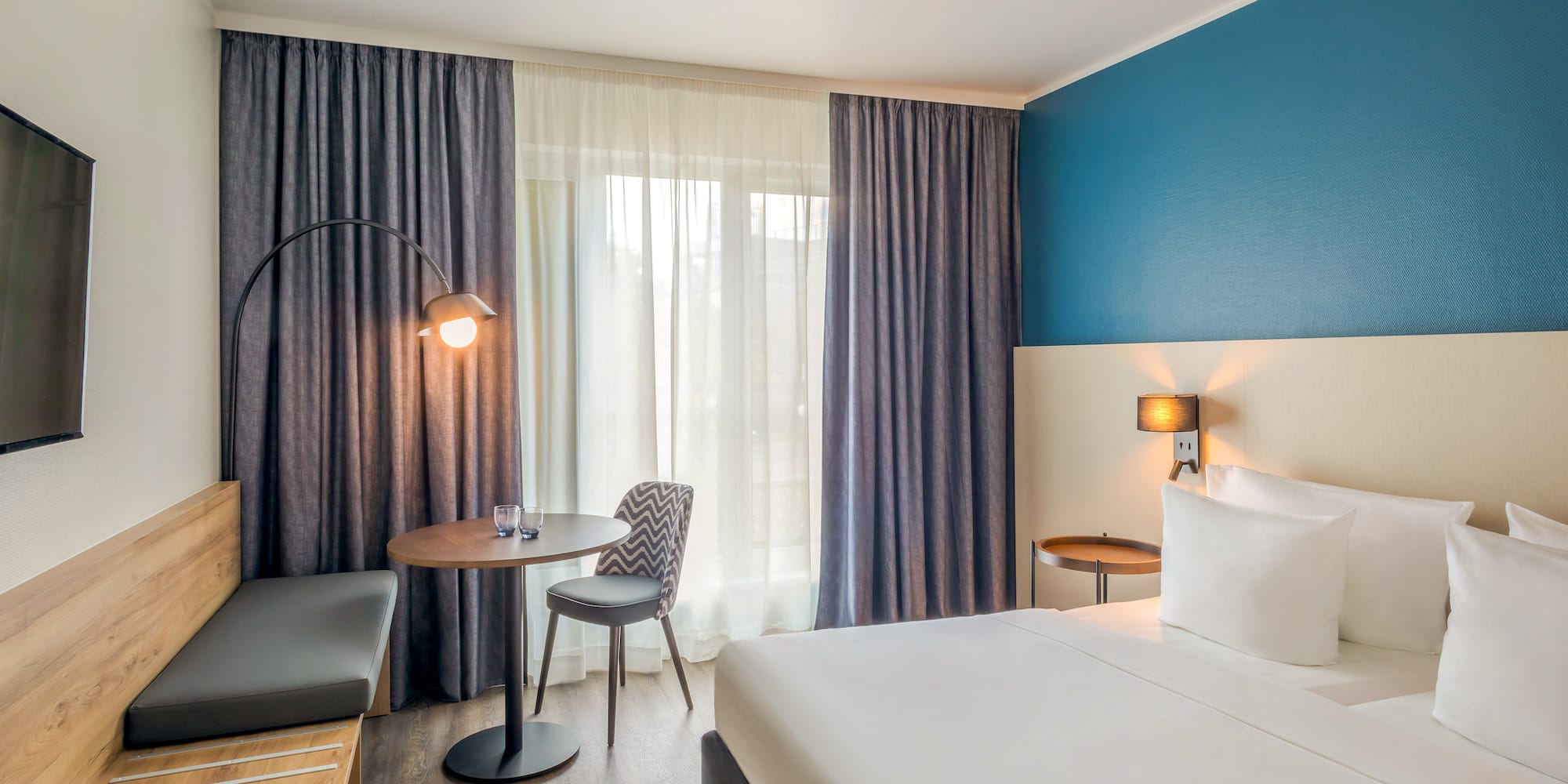 a room with a bed and a table and chairs