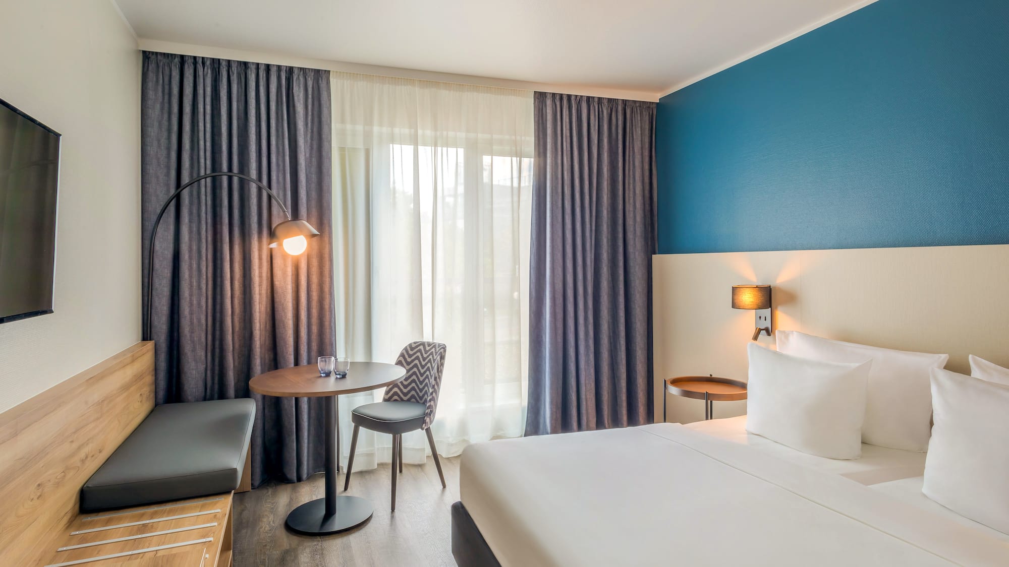 a room with a bed and a table and chairs