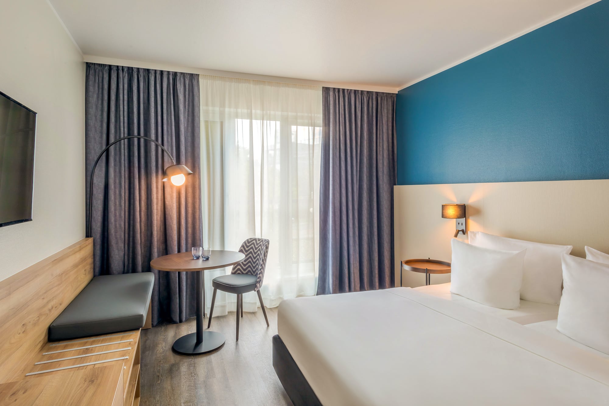 a room with a bed and a table and chairs