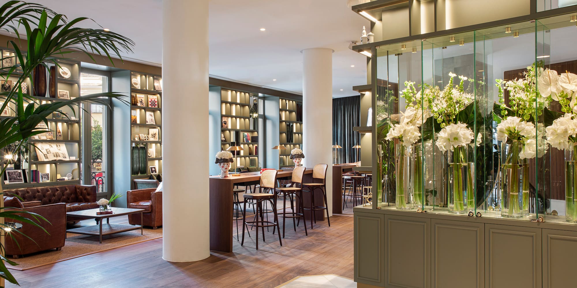 a room with a large glass display case with flowers in it