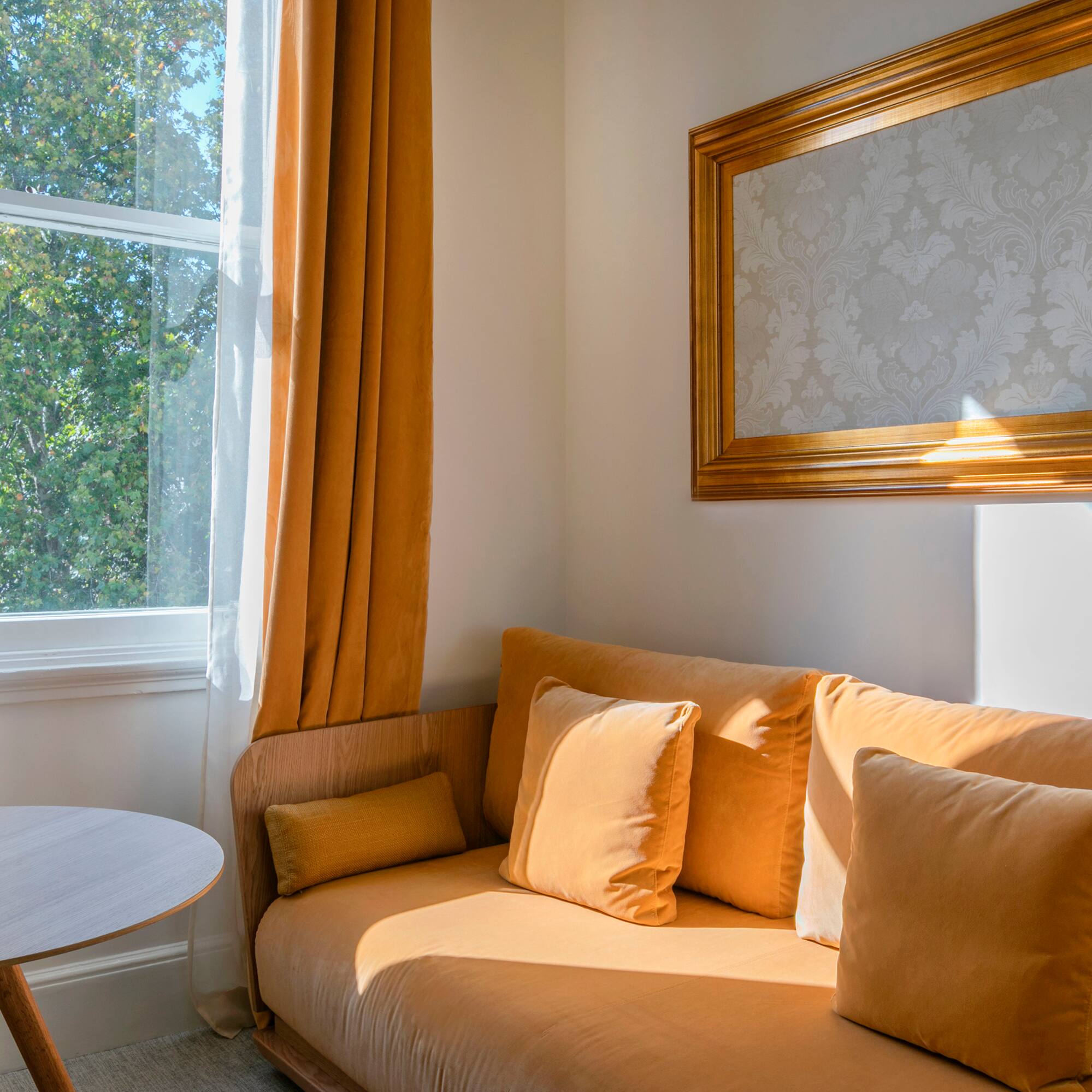 a couch with pillows and a table in front of a window