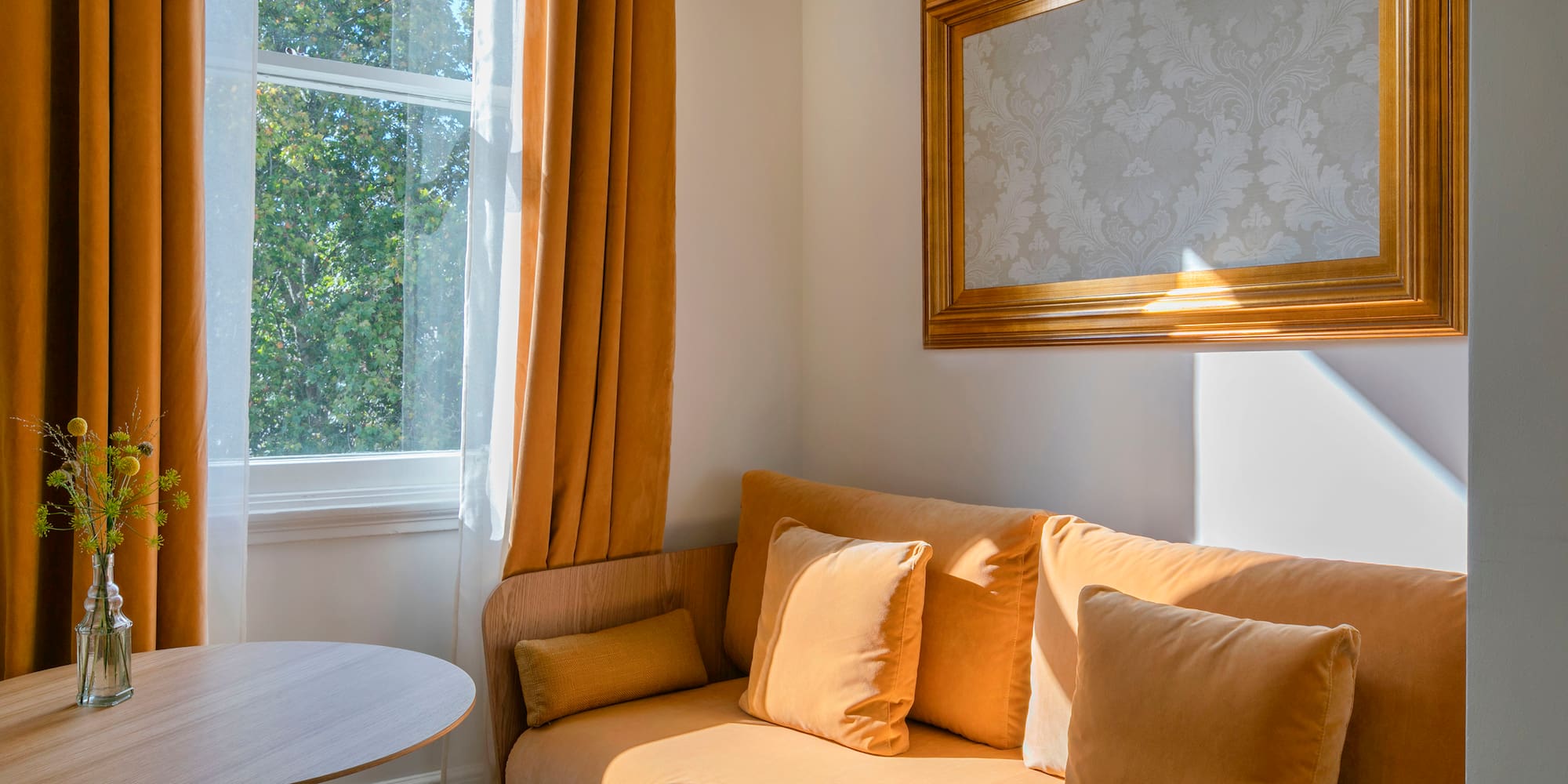 a couch with pillows and a table in front of a window