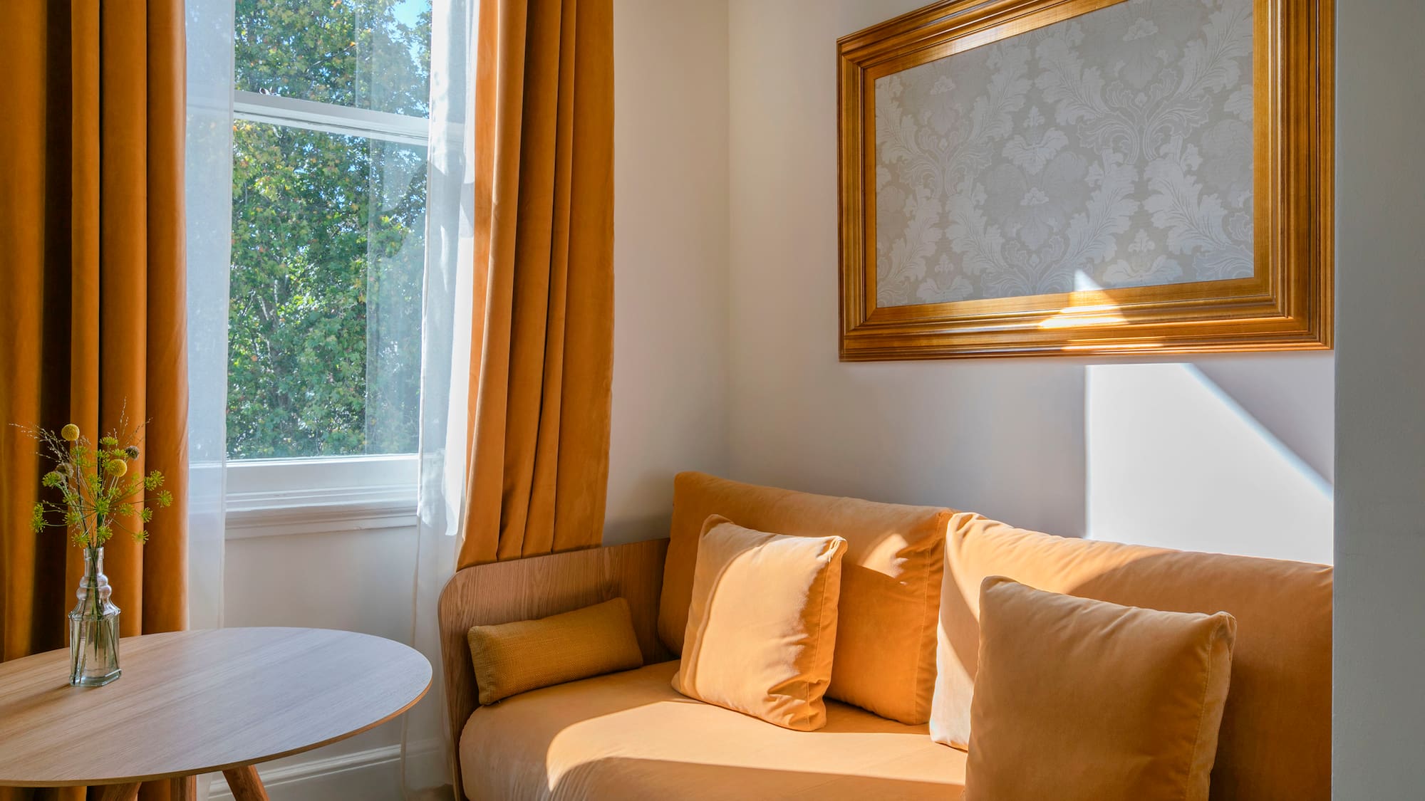 a couch with pillows and a table in front of a window