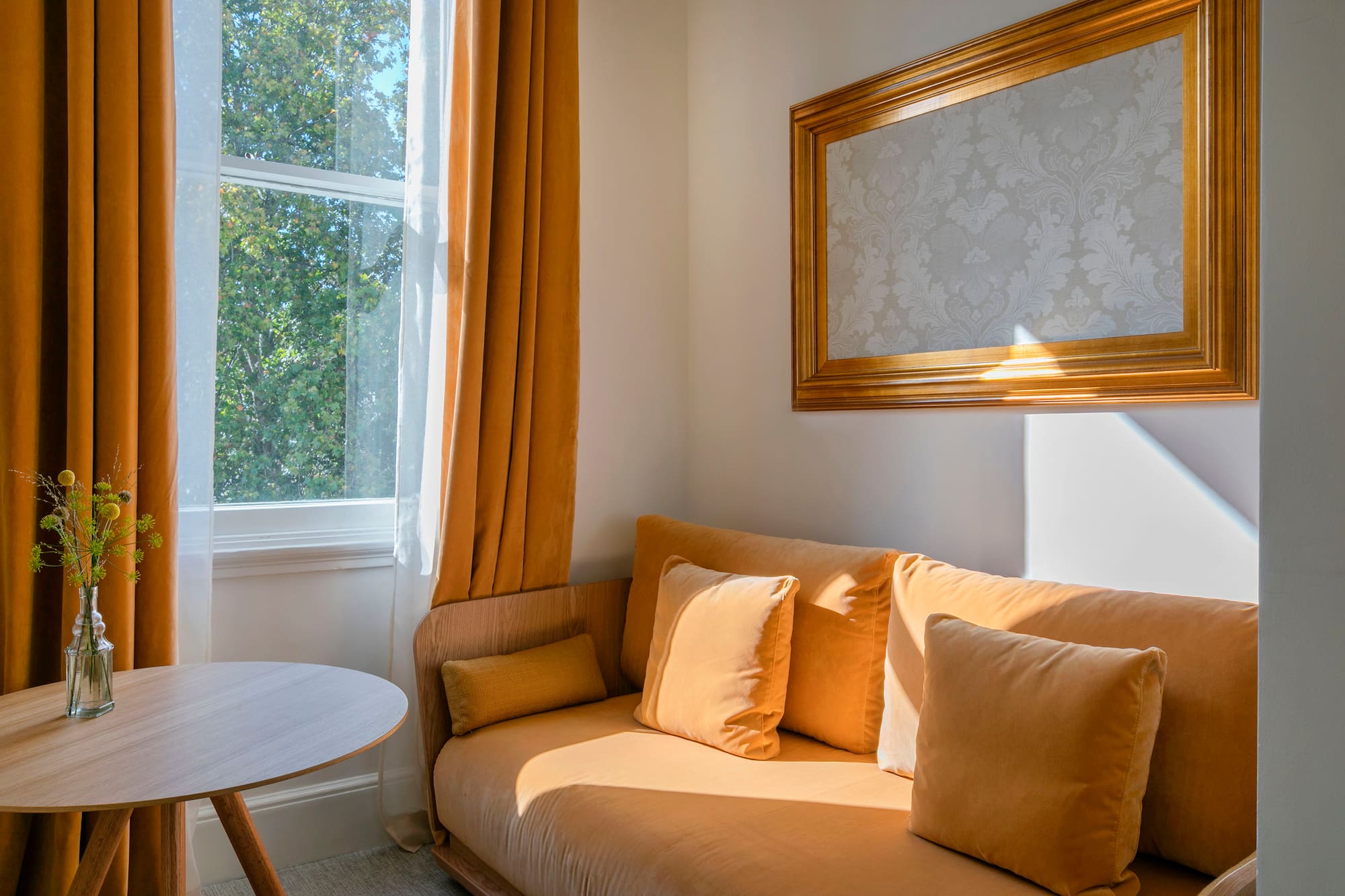 a couch with pillows and a table in front of a window