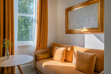 a couch with pillows and a table in front of a window