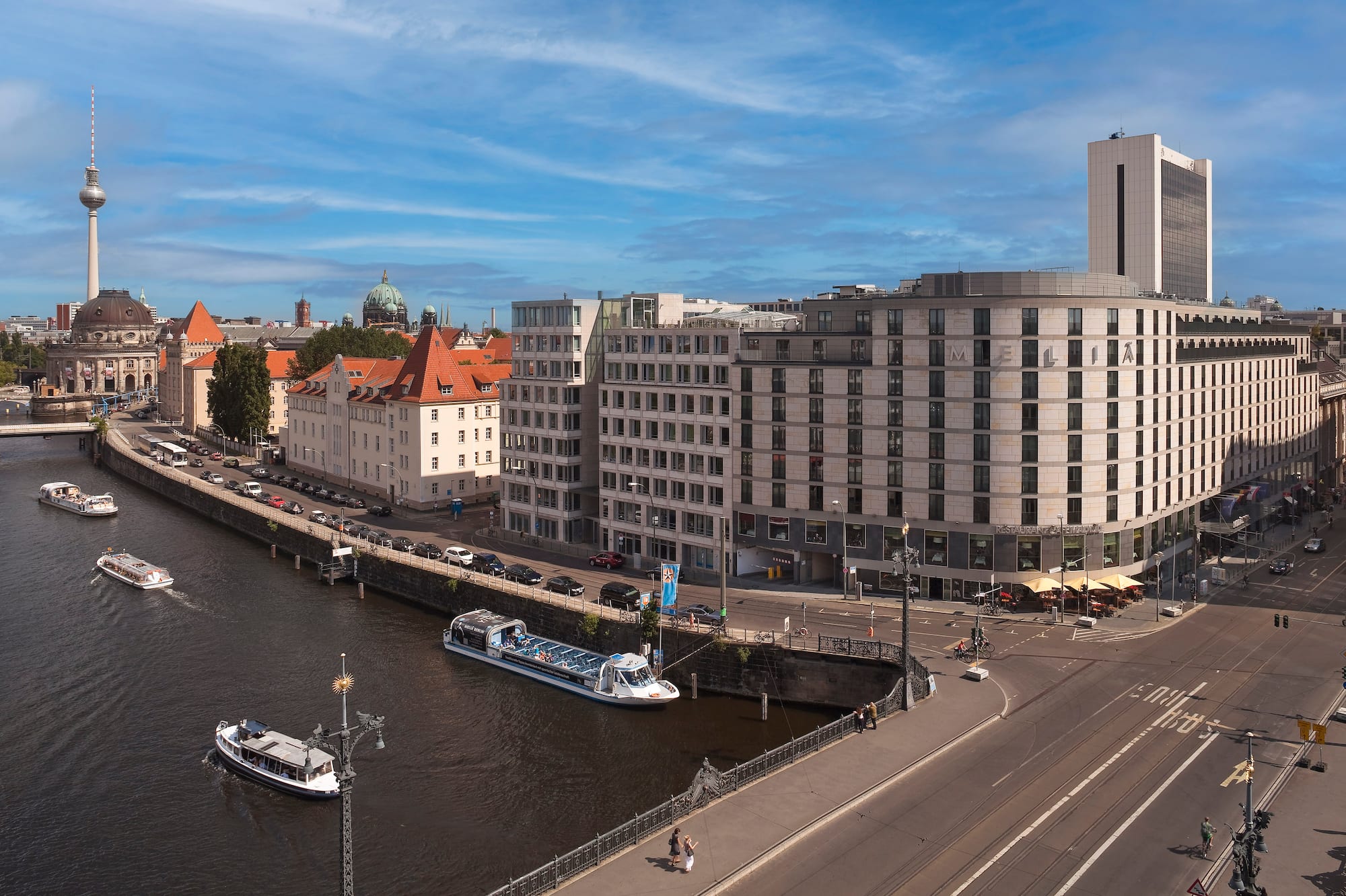 Berlin Spree River, tour boats, TV Tower, and diverse city architecture.