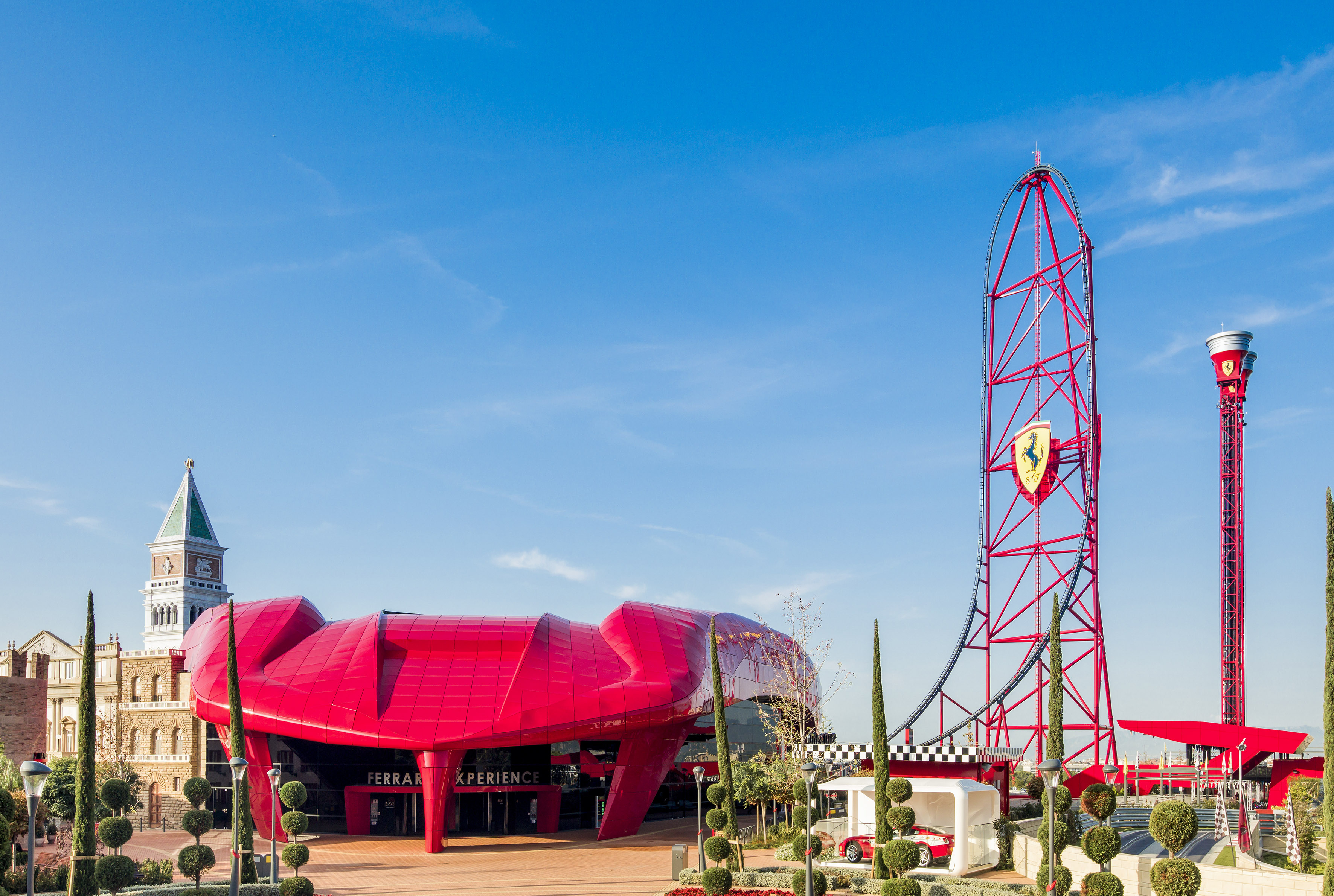 a red roller coaster with a red structure in the background
