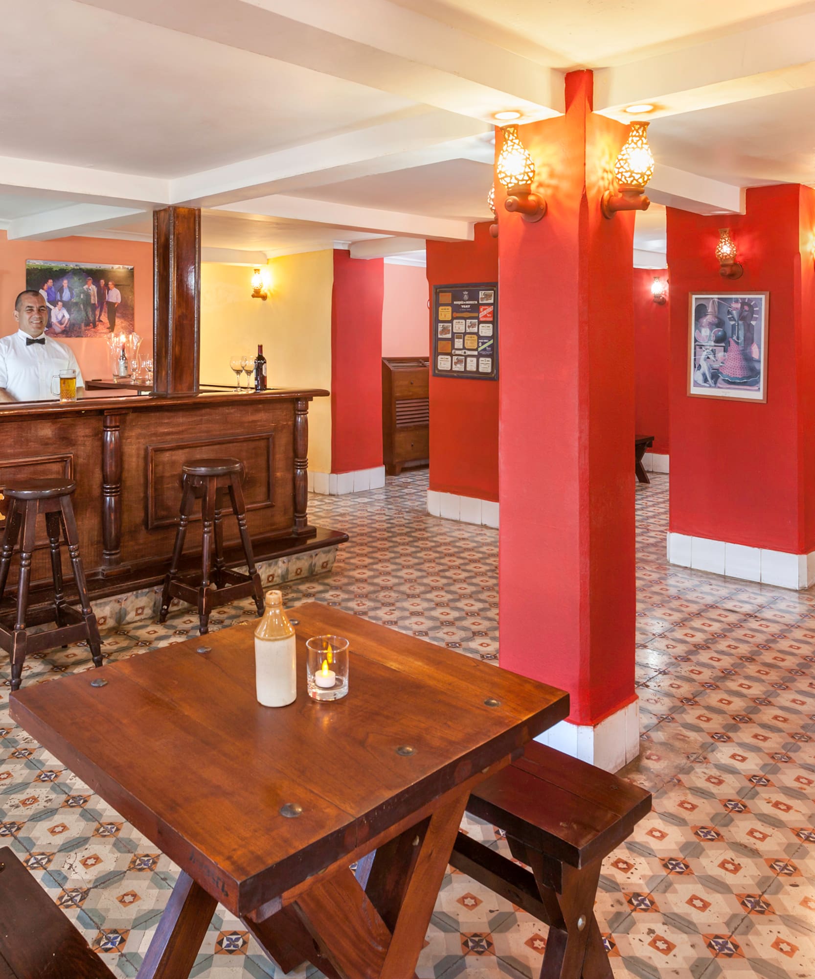 a man behind a counter in a room with red walls