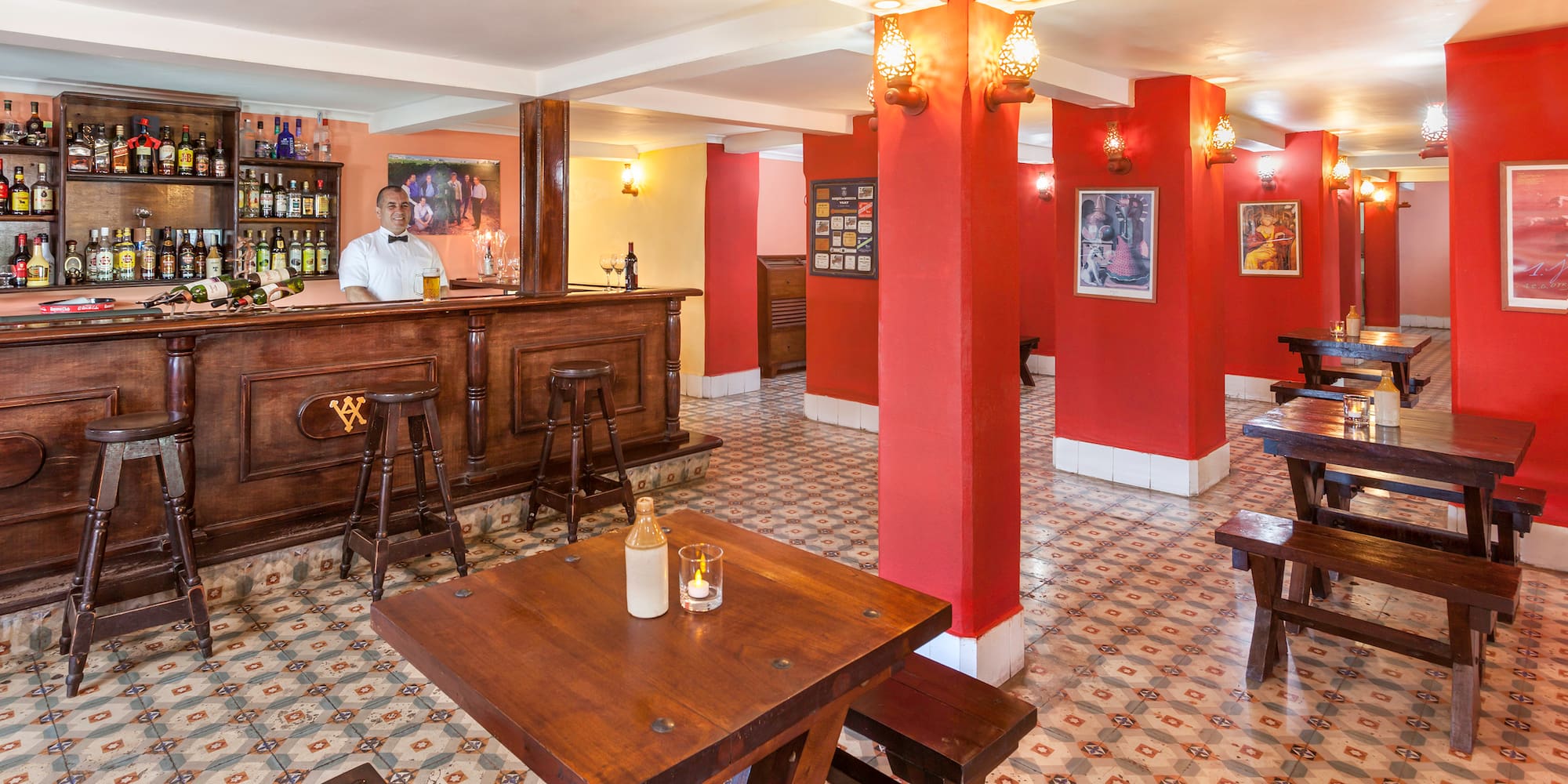 a man behind a counter in a room with red walls