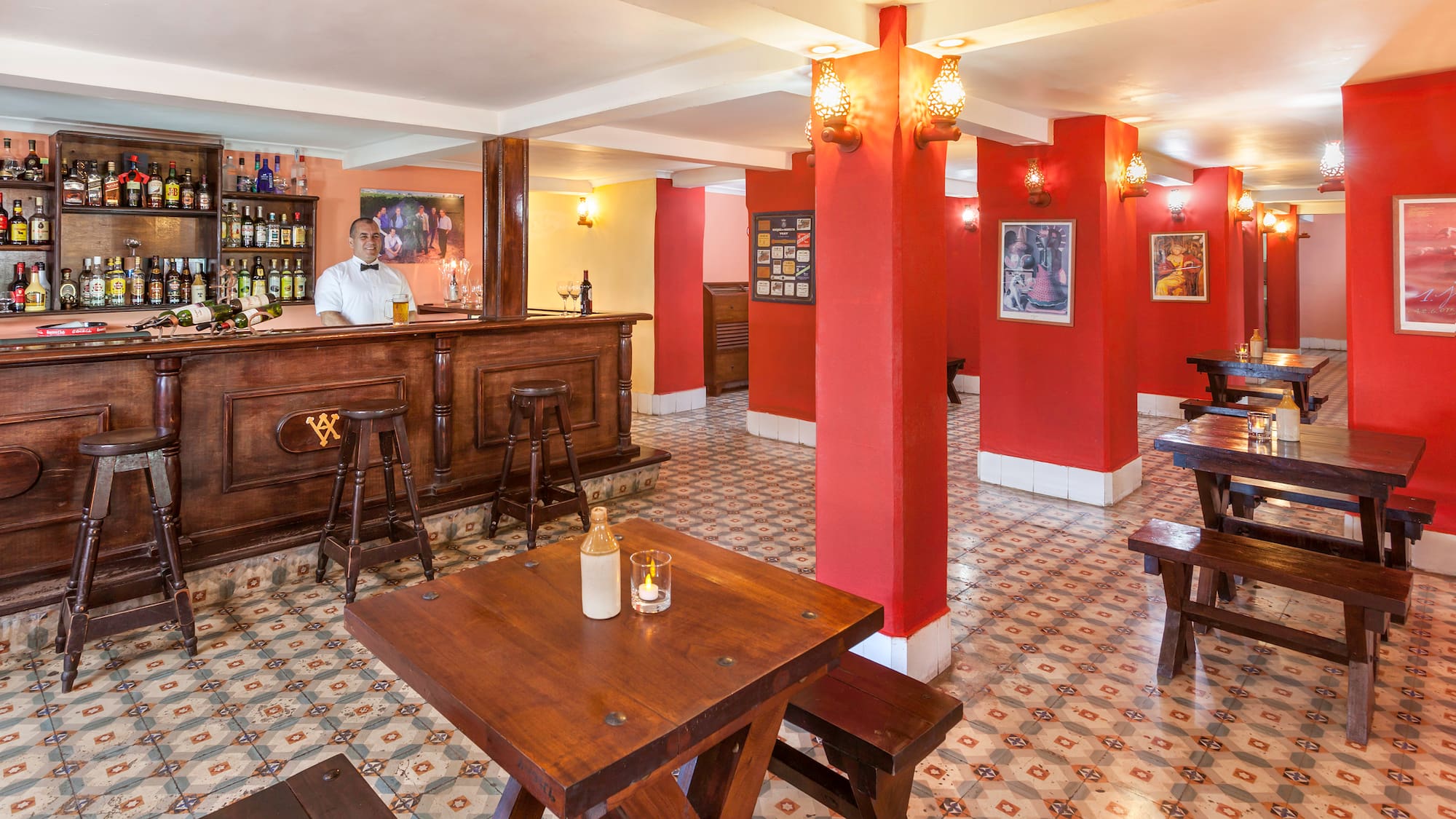 a man behind a counter in a room with red walls