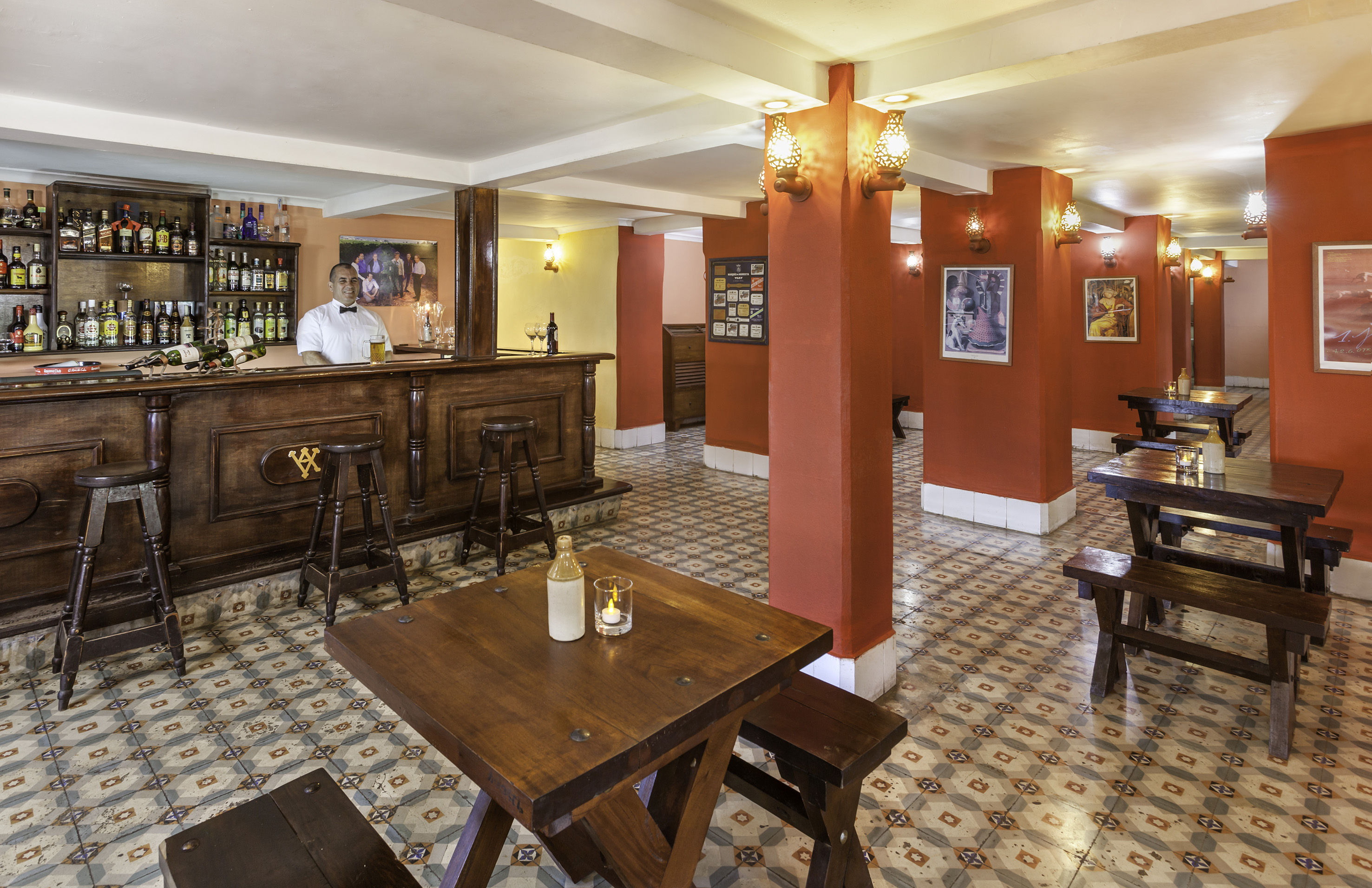 a man behind a counter in a room with red walls