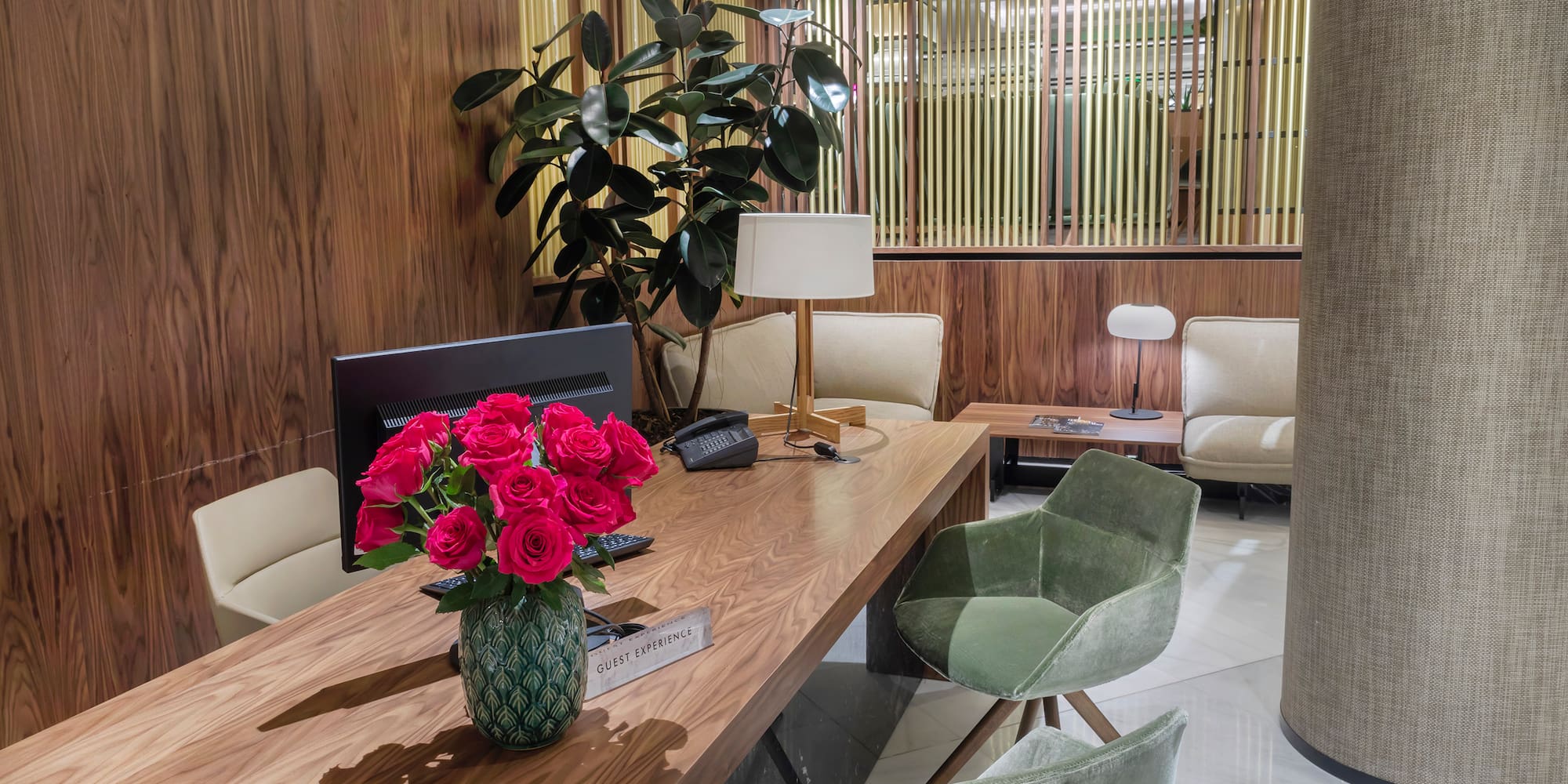 a room with a desk and chairs and a vase of flowers