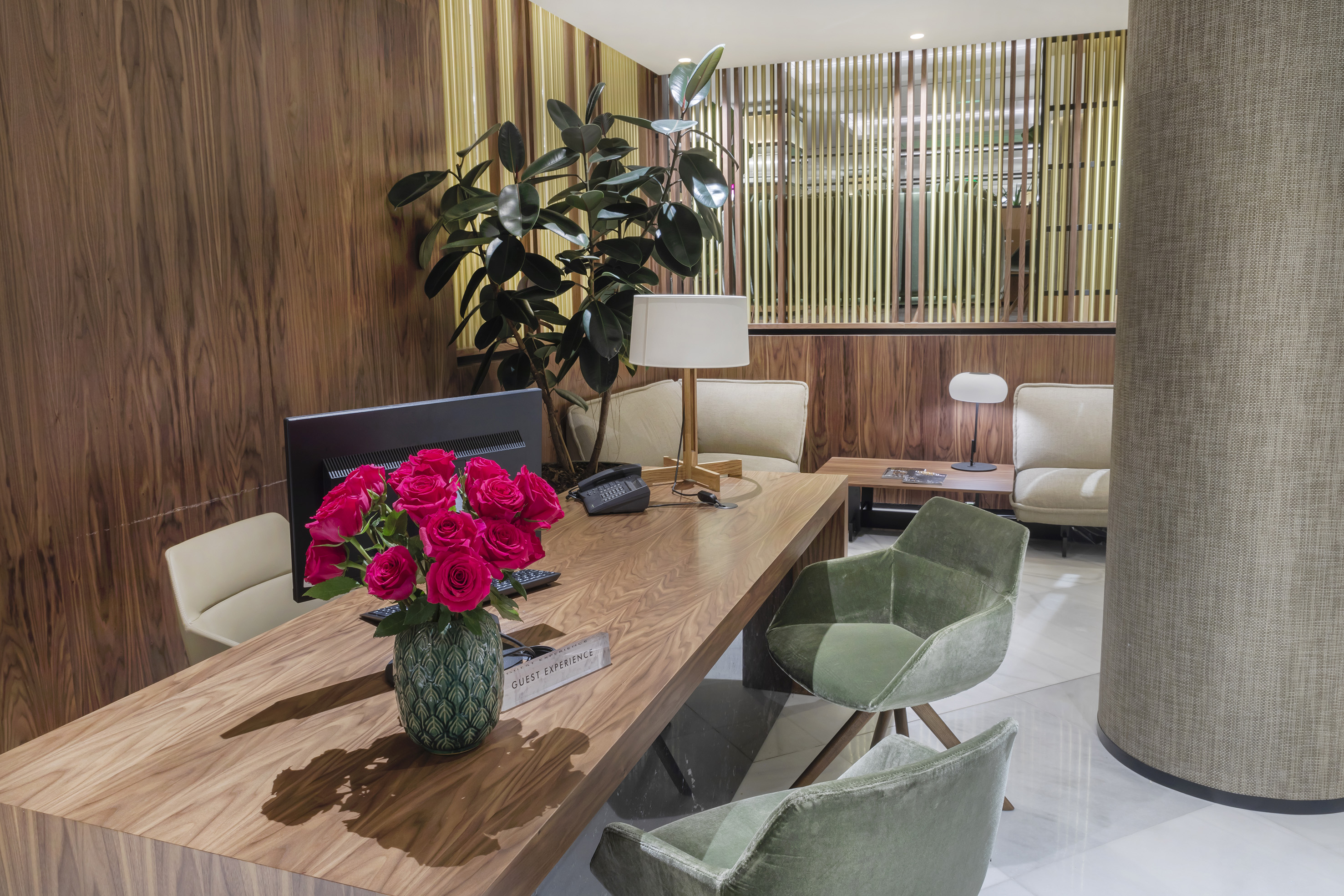 a room with a desk and chairs and a vase of flowers