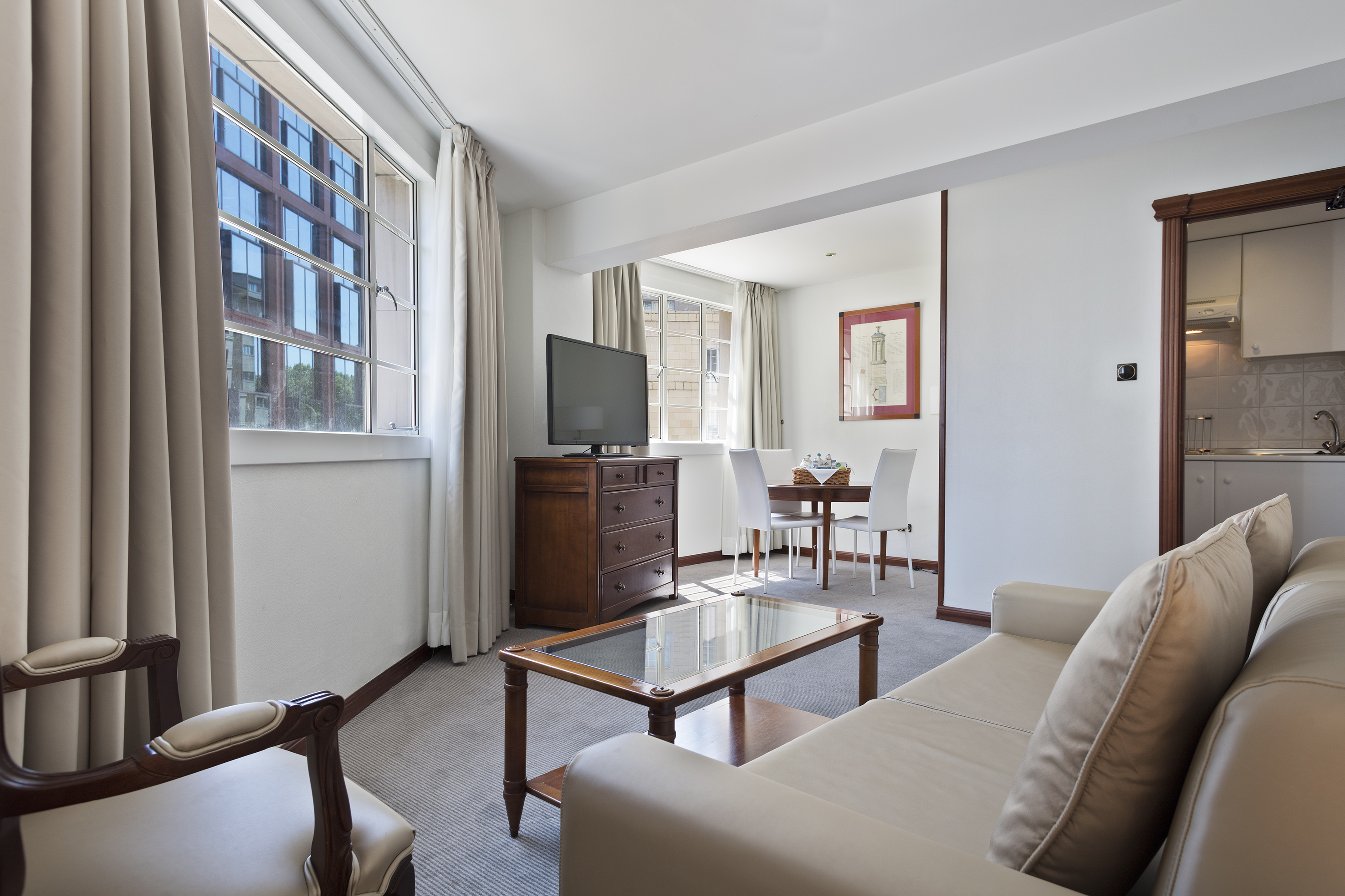 Bright studio apartment with living area, dining table, and kitchenette.