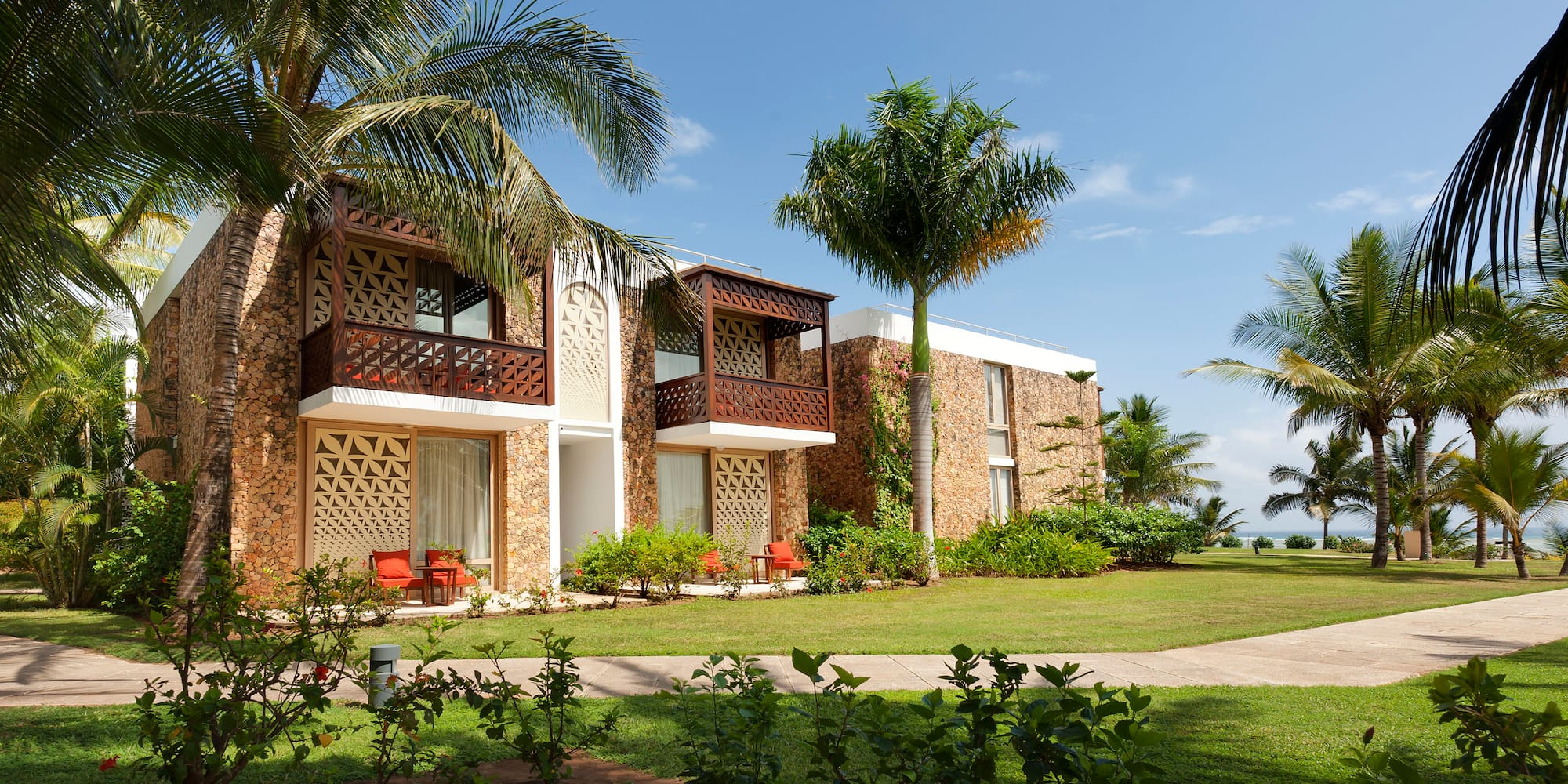 a building with palm trees and grass