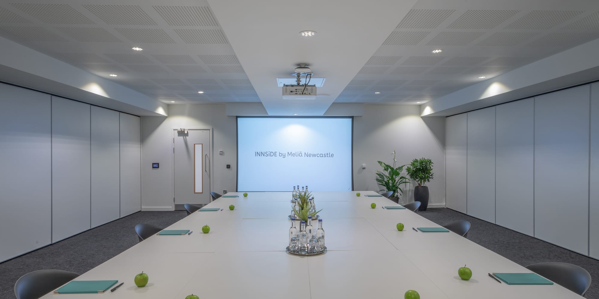 a conference room with a large table and green apples