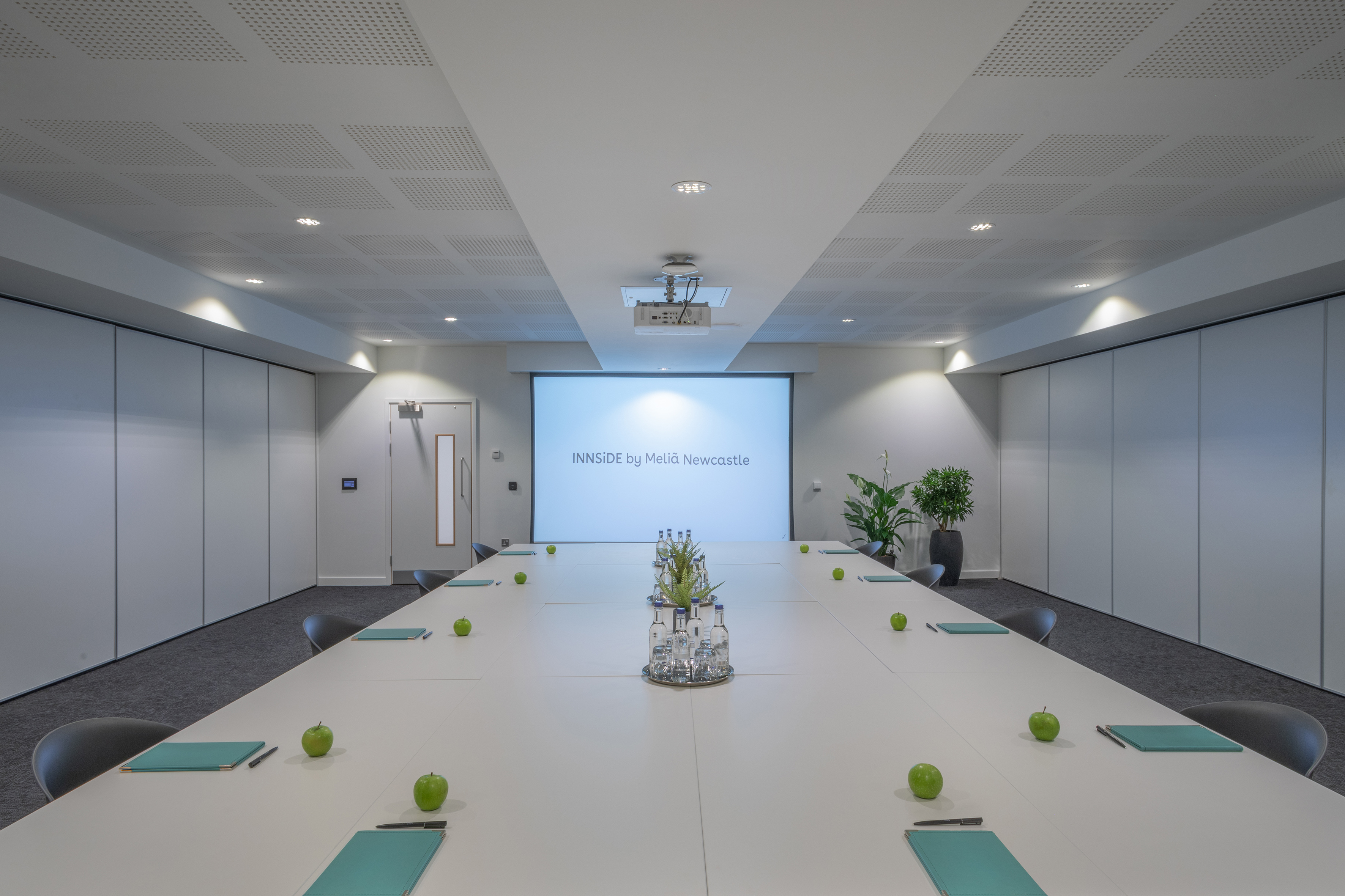 a conference room with a large table and green apples
