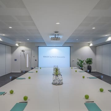 a conference room with a large table and green apples