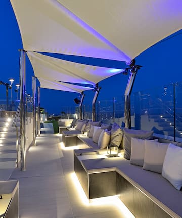 a patio with a large white couch and a blue light