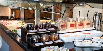a buffet table with food and jars of jam