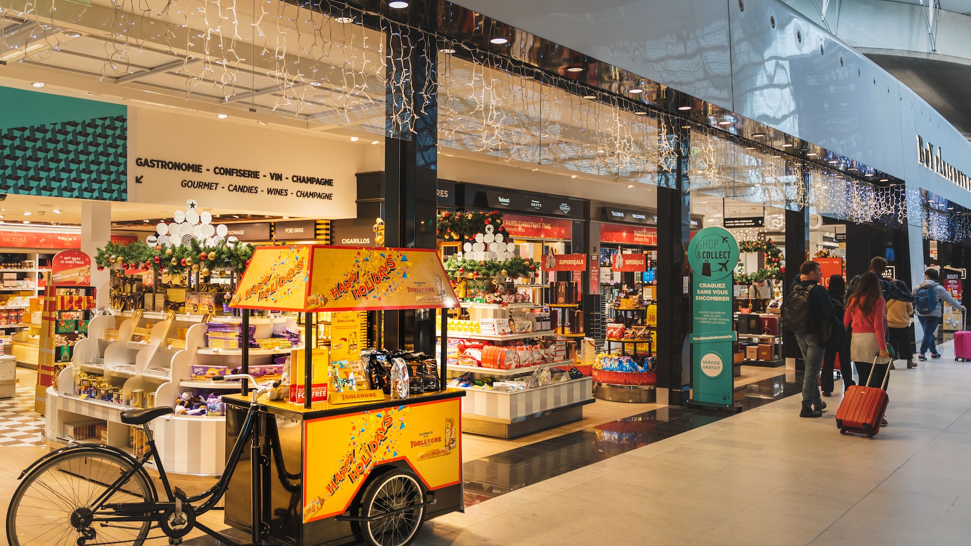 a man walking past a food cart in a mall