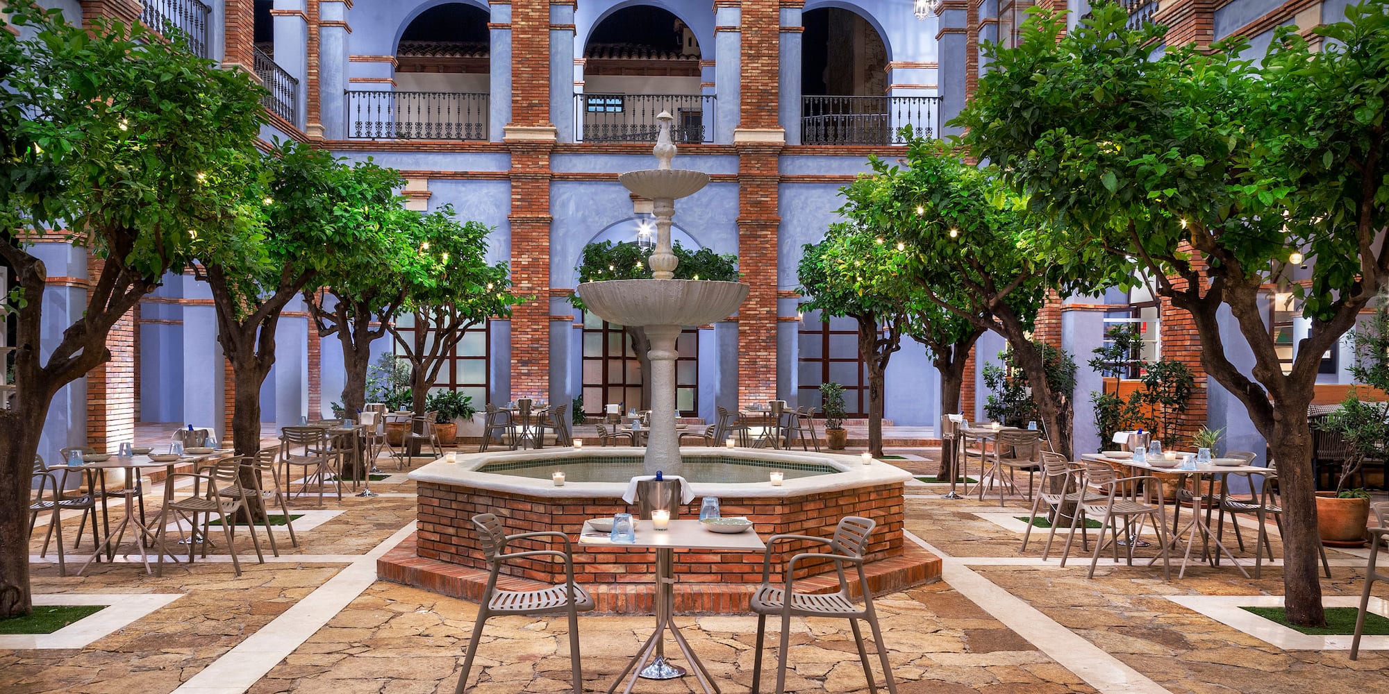 a courtyard with a fountain and trees