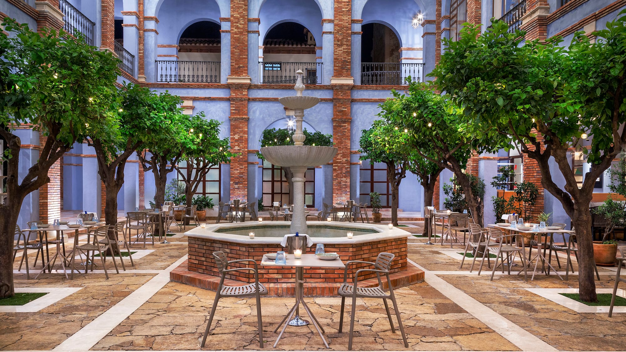a courtyard with a fountain and trees