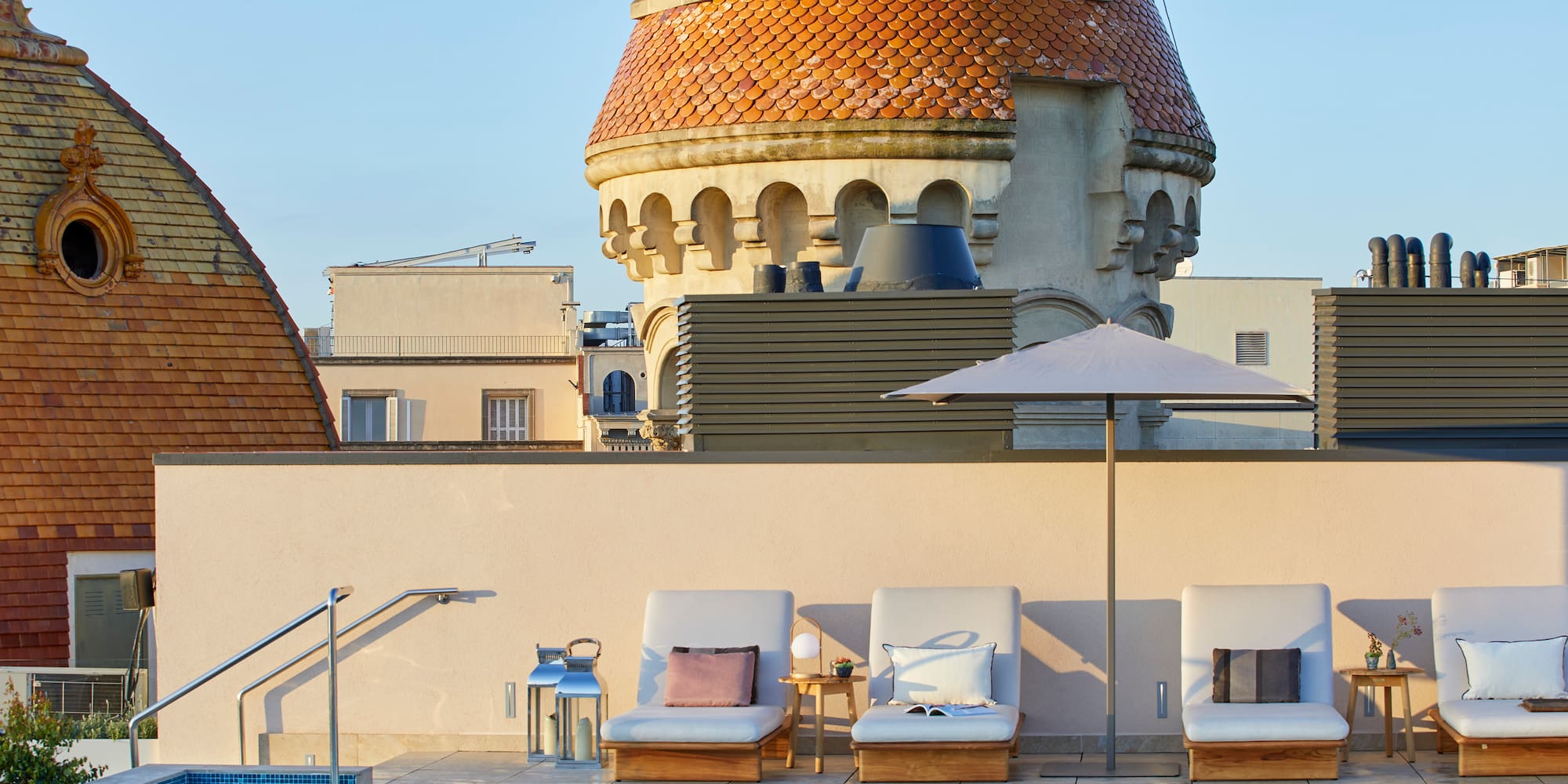 a pool with chairs and umbrellas by a building