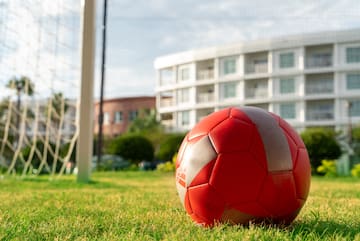 a red and white football ball on grass