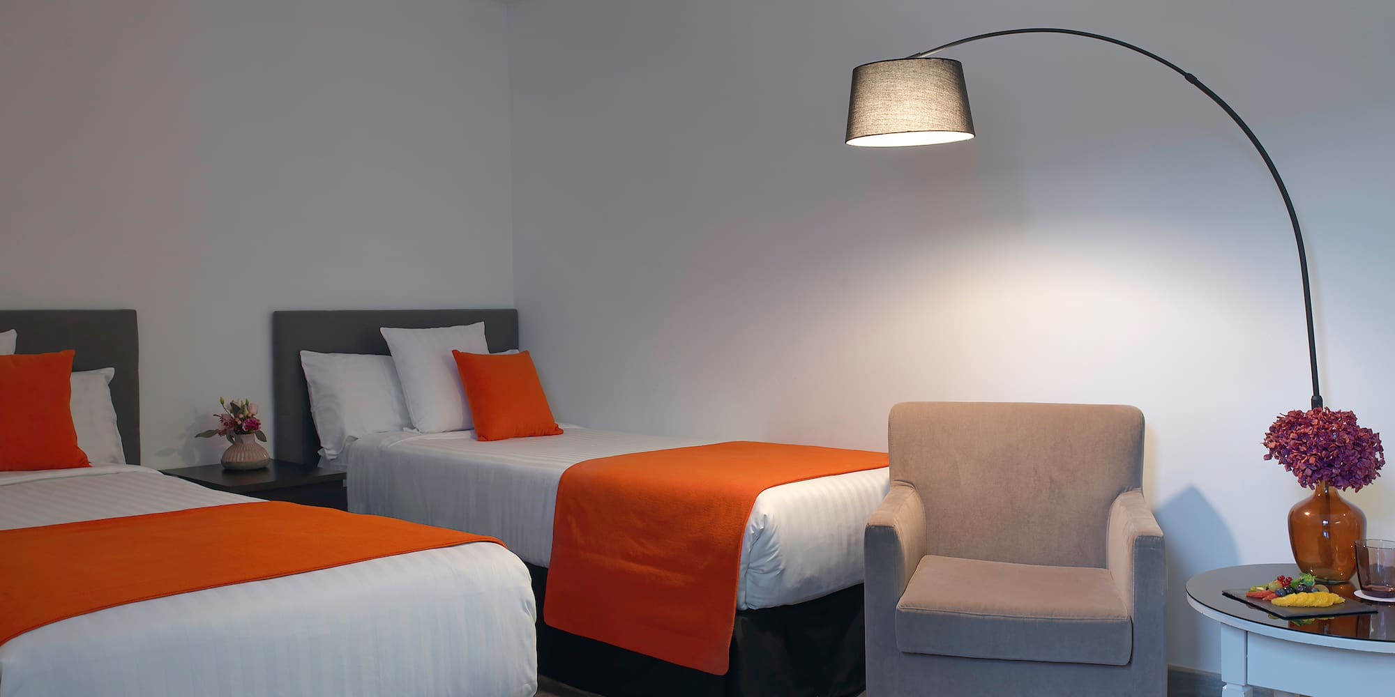 a room with two beds and a lamp