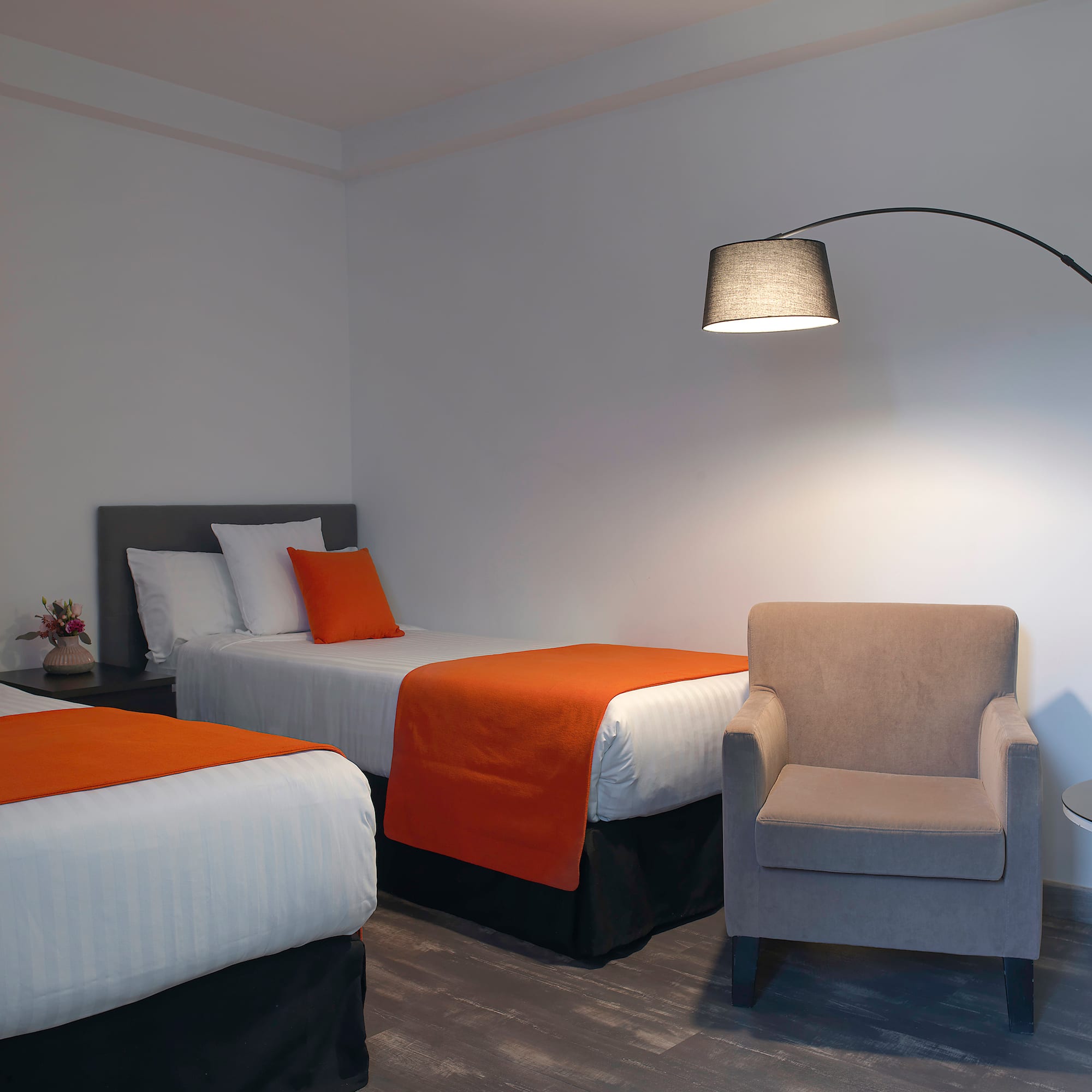 a room with two beds and a lamp