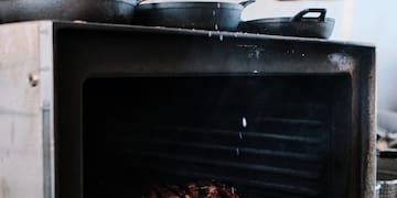 a person cooking meat in an oven