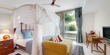 a bedroom with a canopy bed and a couch