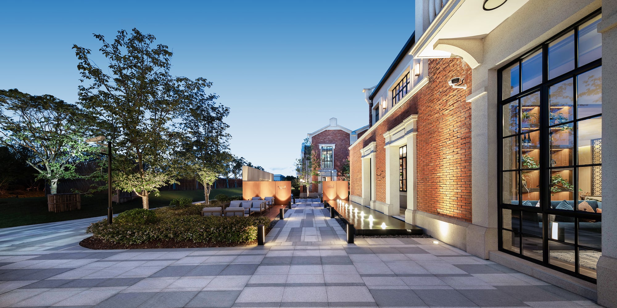 a brick building with a bench and trees
