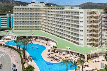a large hotel with a pool and palm trees