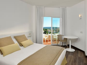 a bedroom with a table and chairs