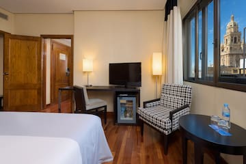 a room with a bed and a television