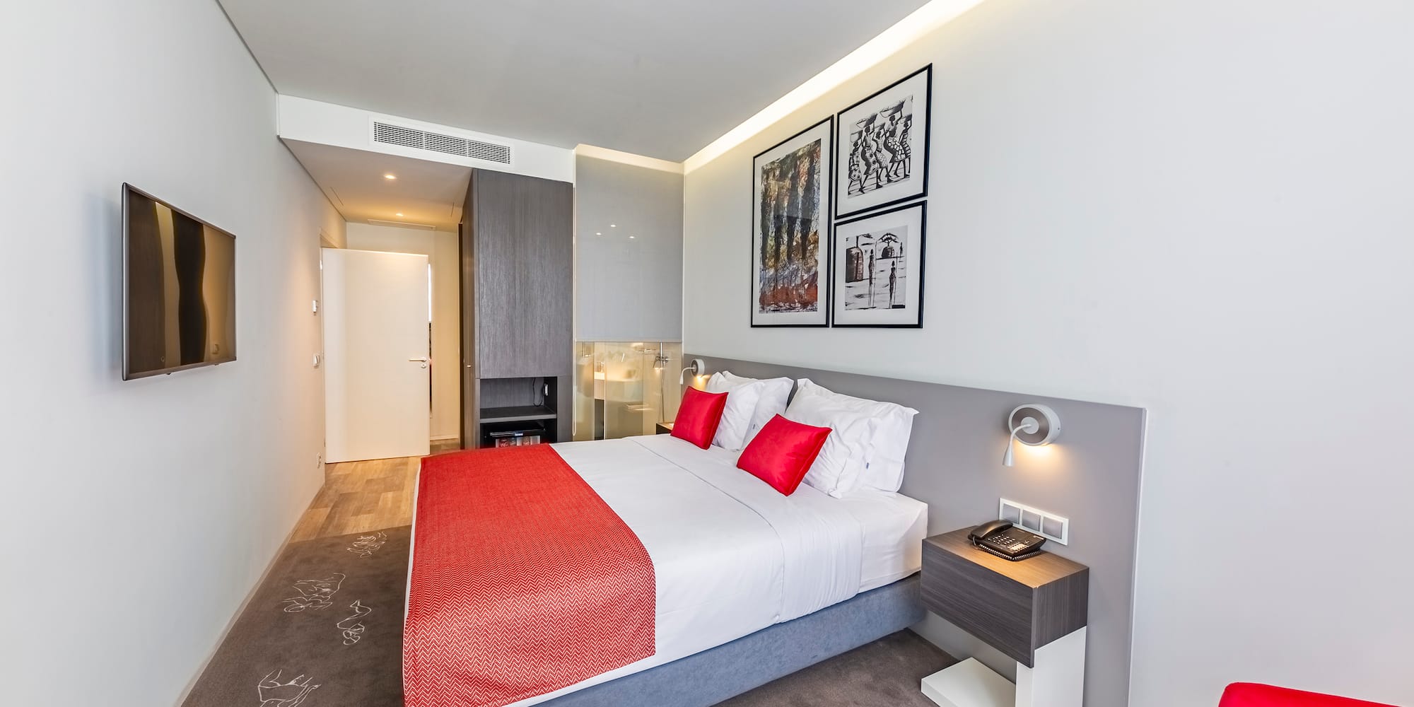 a bed with red and white pillows