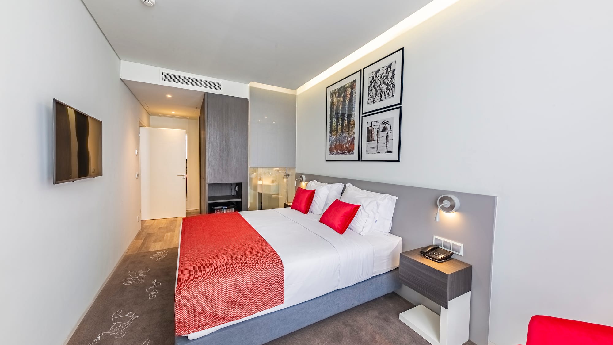 a bed with red and white pillows