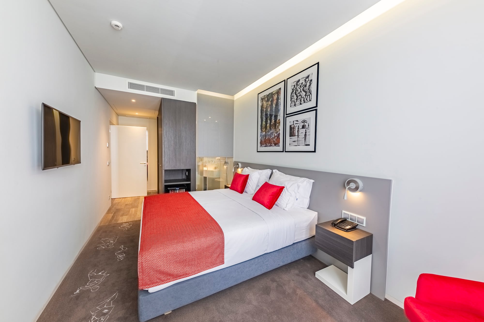 a bed with red and white pillows