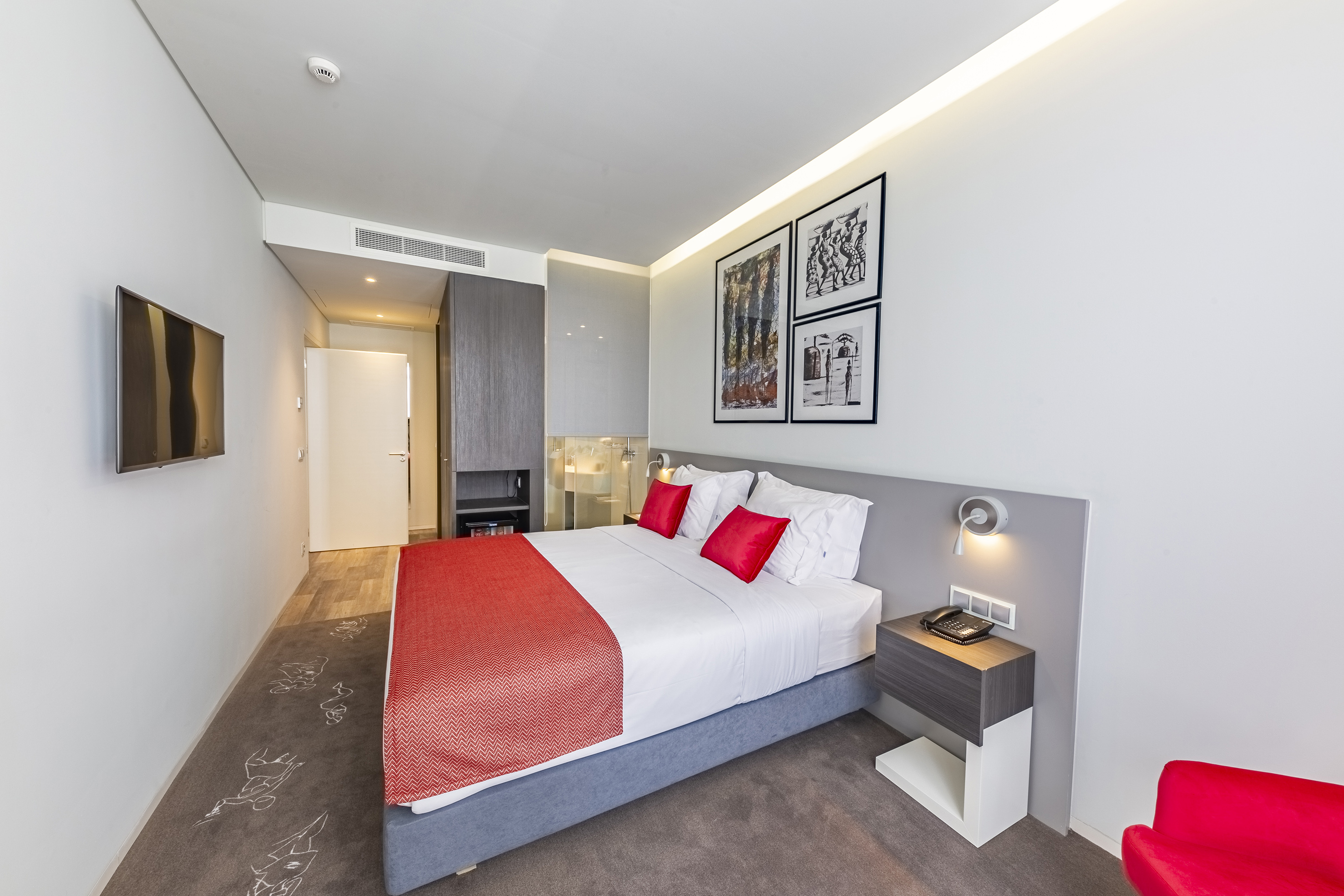 a bed with red and white pillows